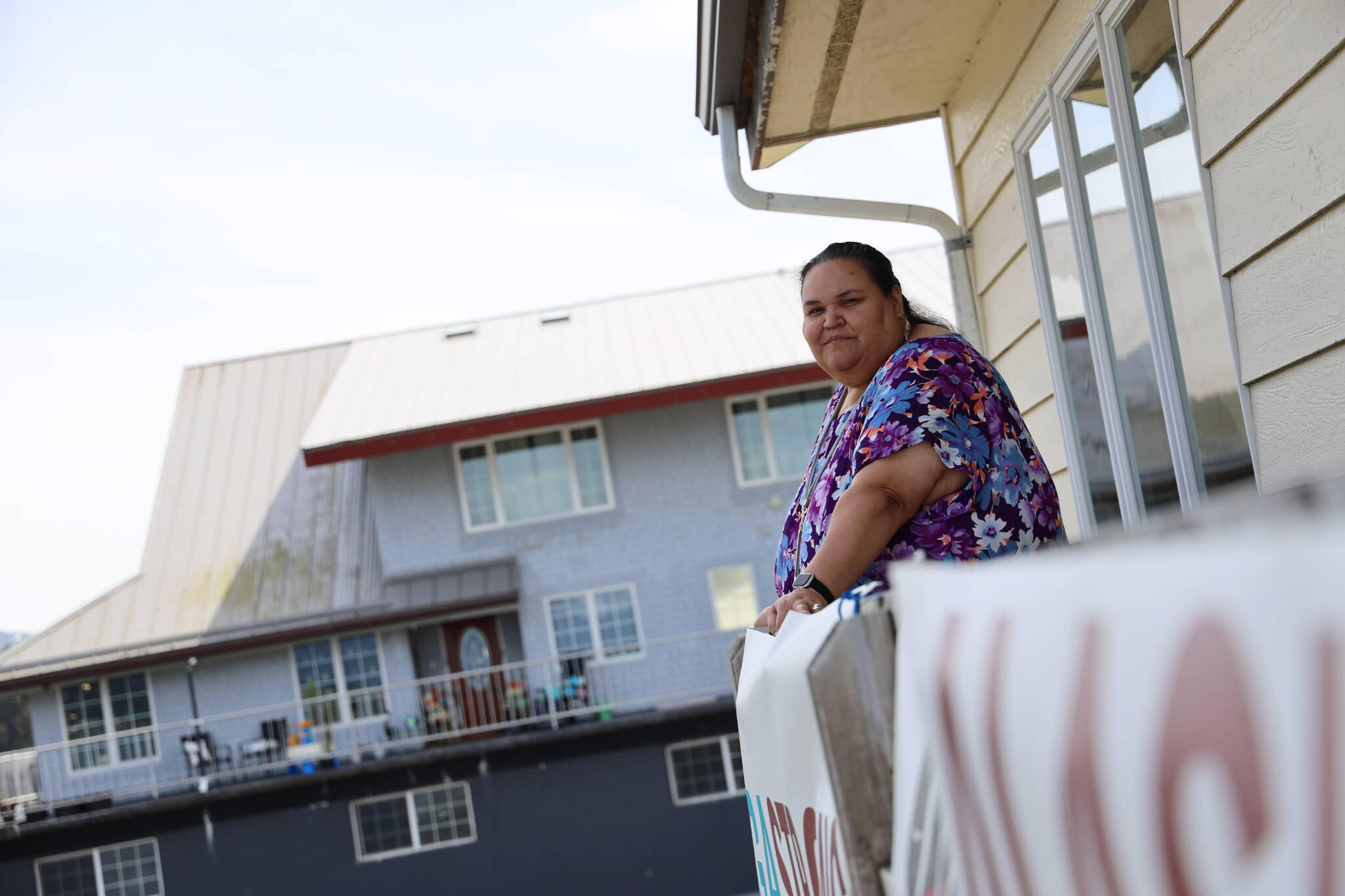 Award-winning Juneau writer Vera Starbard stands on her balcony on Douglas Island that displays banners across Gastineau Channel in support of the Writer’s Guild of America union strike currently going on across Hollywood and the country. (Clarise Larson / Juneau Empire)