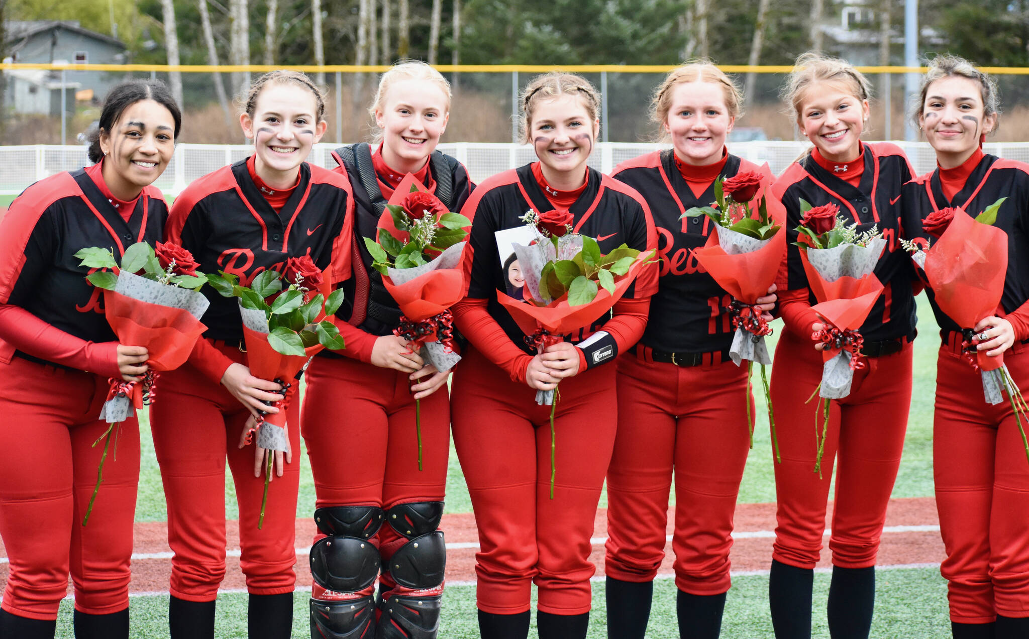 This photo shows Juneau-Douglas High School: Yadaa.at Kalé Crimson Bears senior softball players Amira Andrews, Carlynn Casperson, Anna Dale, Gloria Bixby, Mariah Schauwecker, Zoey Billings and Bailey Hansen. JDHS plays in a semifinal against Sitka at 6 p.m. Friday in the Region V Tournament on Sitka’s Moller Field. (Courtesy Photo / JDHS Softball)