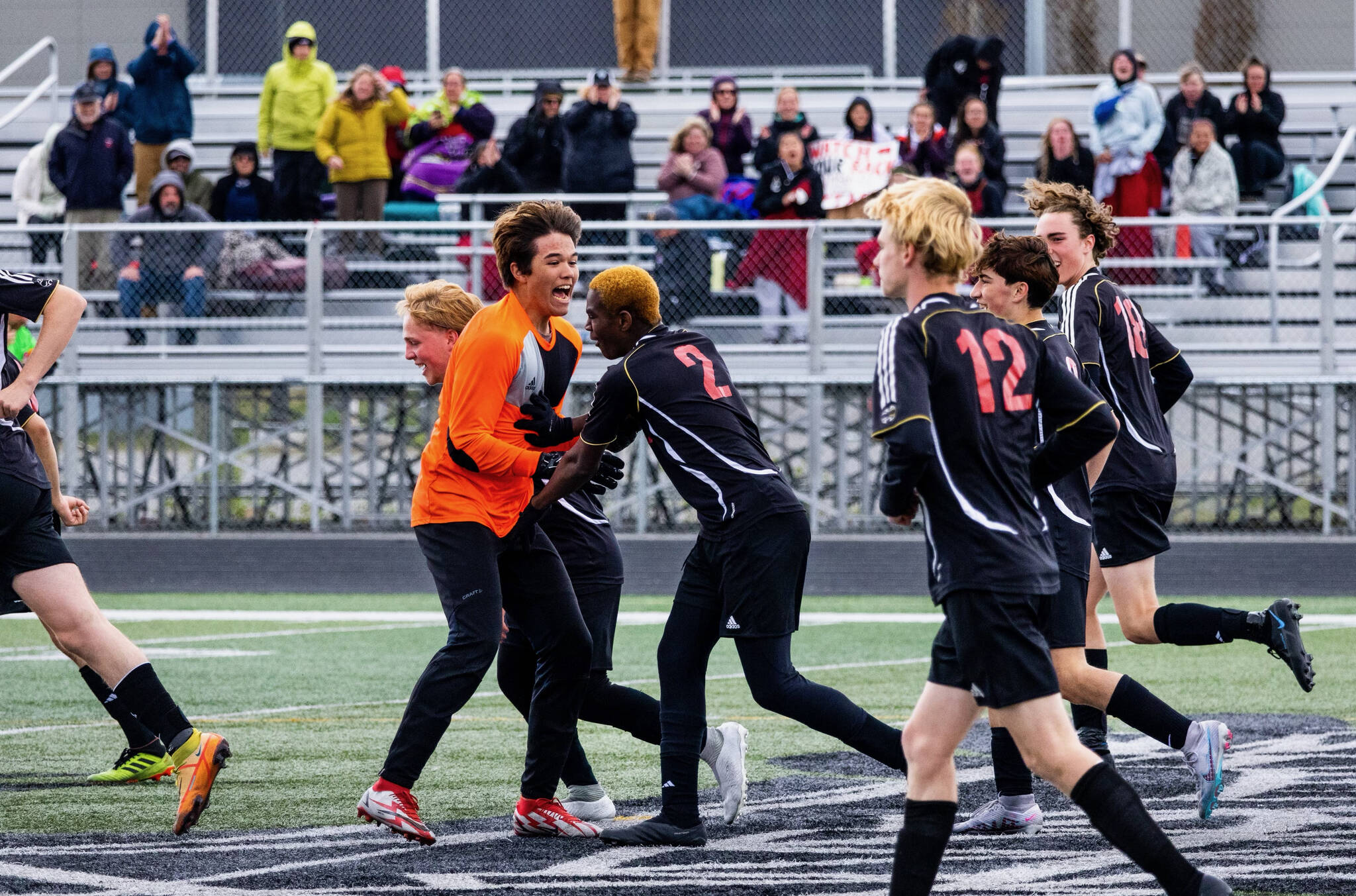 JDHS boys junior keeper Alex Mallott celebrates a goal by sophomore Ahmir Parker (2) during the Crimson Bears 2-0 win over Ketchikan in the ASAA DII Boys State Soccer semifinal, Friday, at West Anchorage High School. (Courtesy Photo / JDHS soccer)