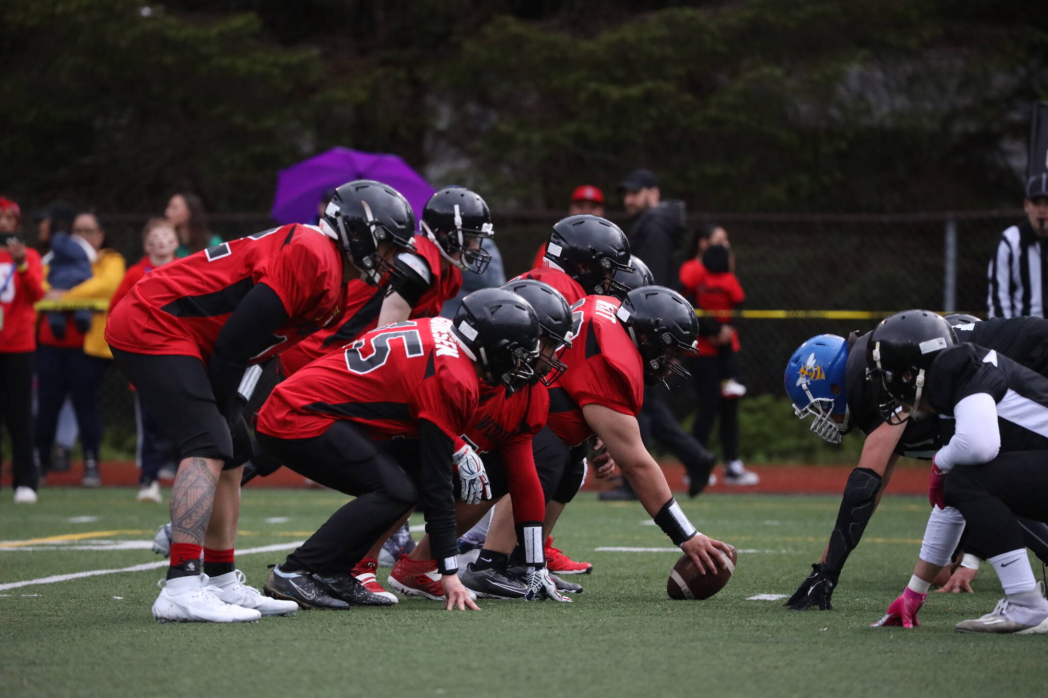 Players line up during the final quarter of Juneau Alumni Football game on Friday at Adair-Kennedy Memorial Park. (Clarise Larson / Juneau Empire)