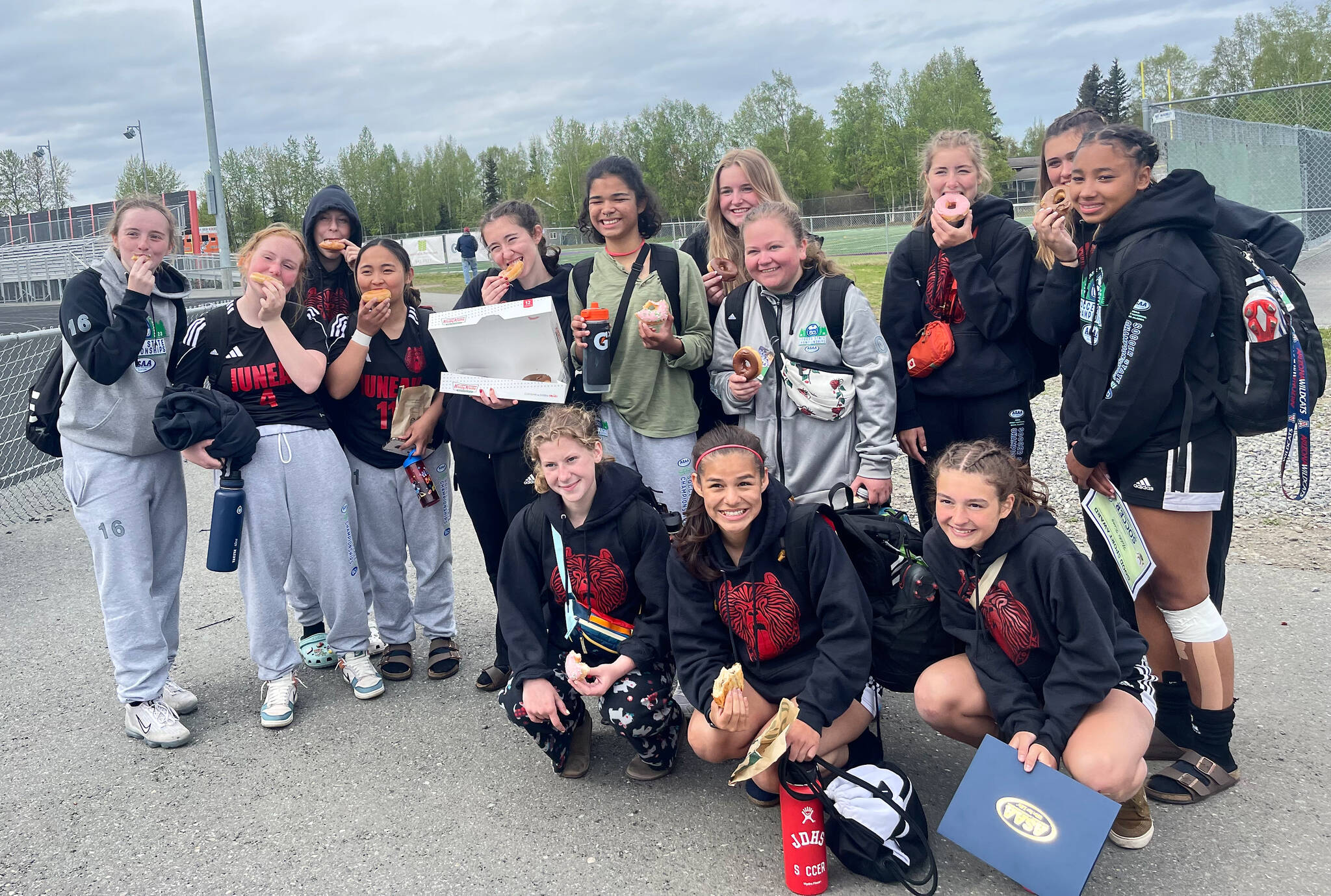 The Juneau-Douglas High School: Yadaa.at Kalé Crimson Bears girls soccer team pose with snacks after their loss to North Pole in the ASAA DII Girls Soccer State Championships, Saturday, at West Anchorage High School (Courtesy Photo / JDHS Soccer)