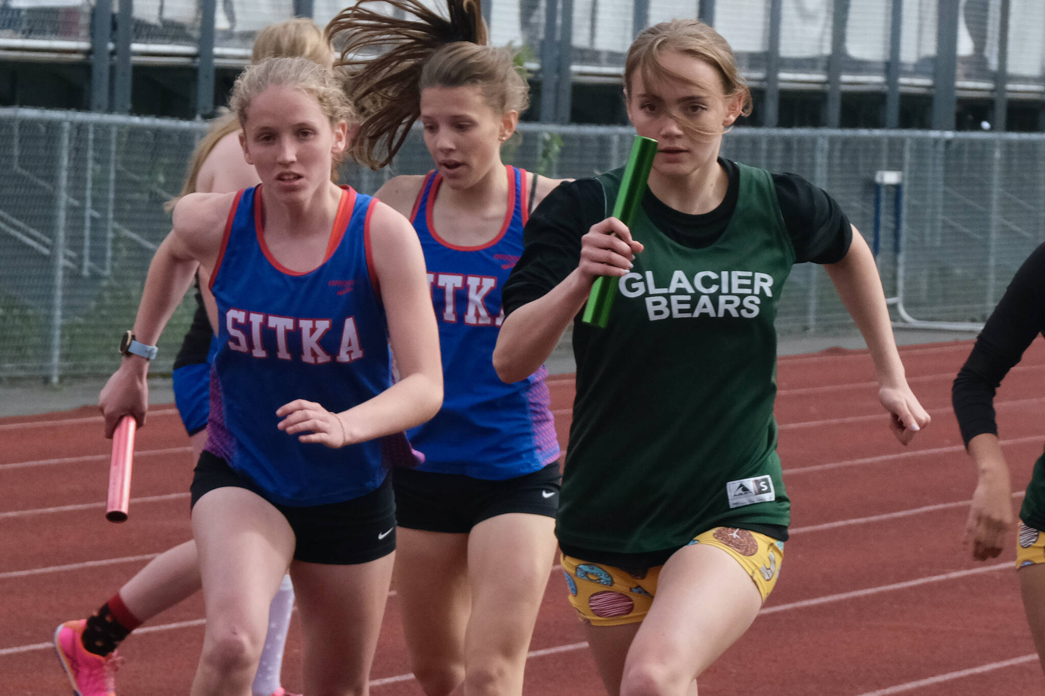 Sitka sophomore Clare Mullin and Haines senior Avari Getchell start the anchor leg of the Division II girls 4x400 relay after taking baton passes from Sitka freshman Natalie Hall and Haines sophomore Ari’el Godinez Long during the Region V Track & Field Championships. Sitka performed well at the state championship this weekend, earning a Division II title. (Klas Stolpe / Juneau Empire)