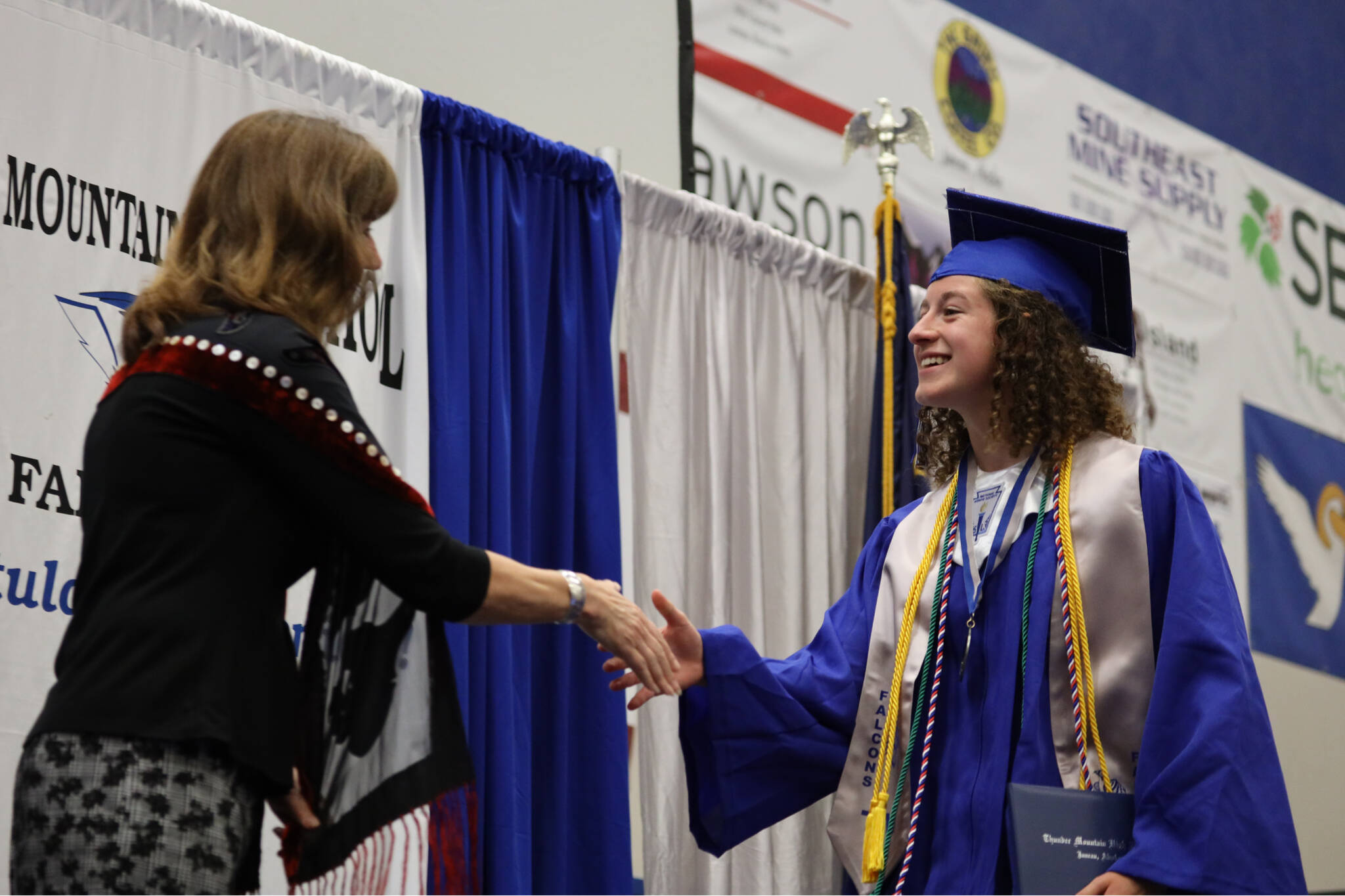 Thunder Mountain High School Senior Class President Mackenzie Olver shakes hands with Juneau School District Superintendent Bridget Weiss after receiving her diploma at the 2023 graduation ceremony Sunday afternoon. (Clarise Larson / Juneau Empire)