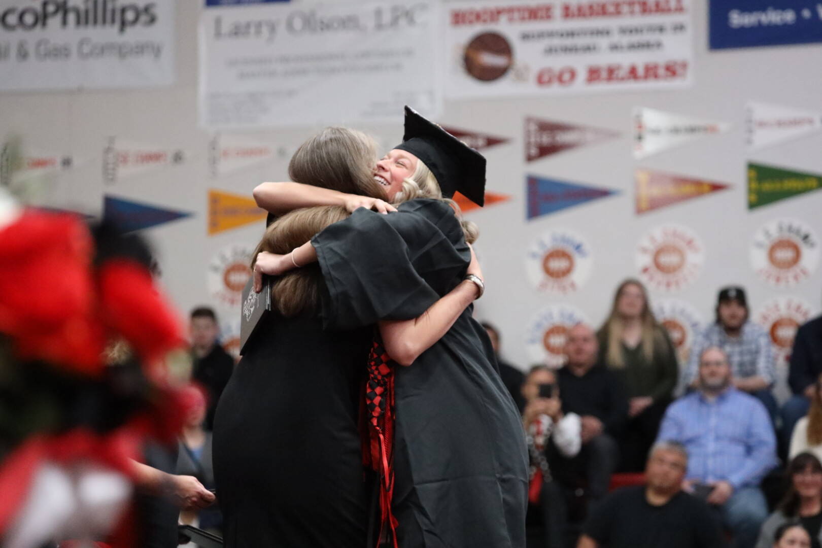 Zoey Billings, a graduating senior at Juneau-Douglas High School: Yadaa.at Kalé, holds her just-received diploma as she hugs Principal Paula Casperson during the school’s graduation ceremony. Billings, one of two student speakers at the ceremony, emphasized the importance of coming together even when circumstances keep people unwillingly separated from each other. (Clarise Larson / Juneau Empire)