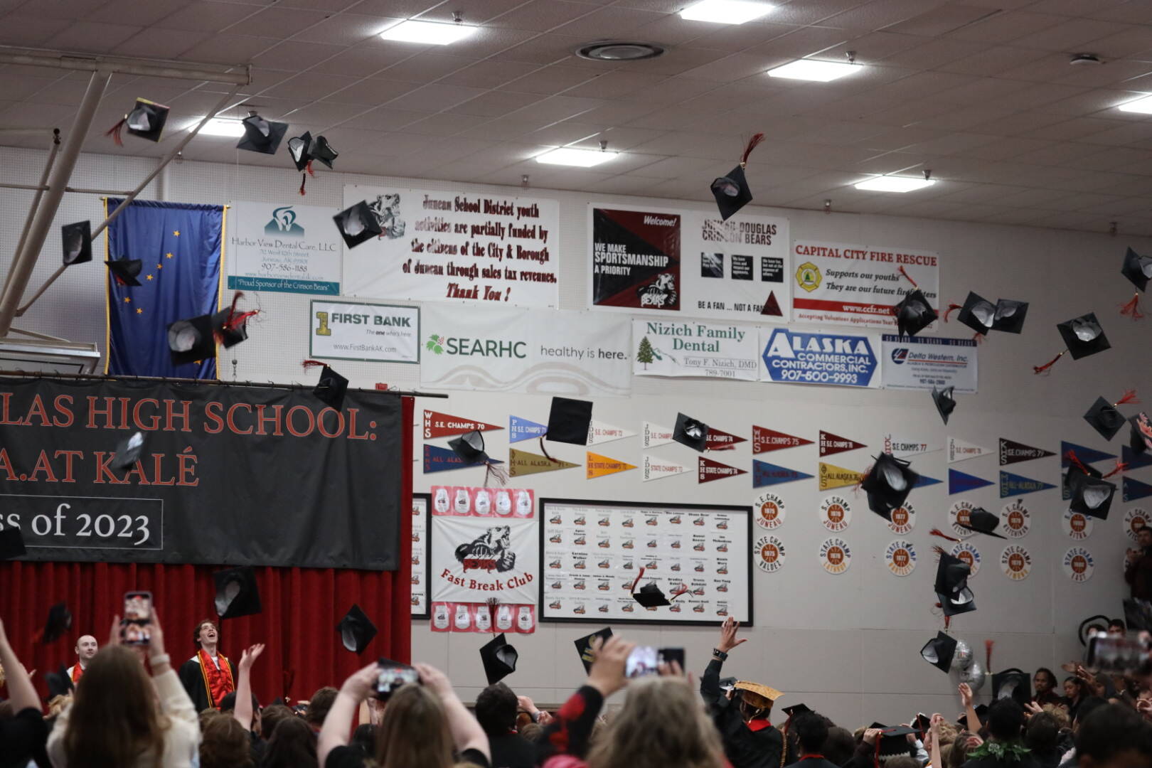 About 140 students at Juneau-Douglas High School: Yadaa.at Kalé toss their caps in the air after receiving the diplomas during Sunday’s graduation ceremony. (Clarise Larson / Juneau Empire)