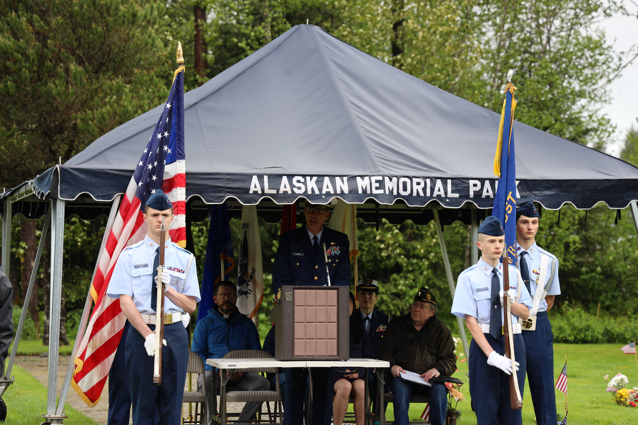 Commander Rear Adm. Nathan A. Moore gives a speech to a crowd gathered at Alaskan Memorial Park as the rain poured down for a service in observance of Memorial Day on Monday morning. (Clarise Larson / Juneau Empire)