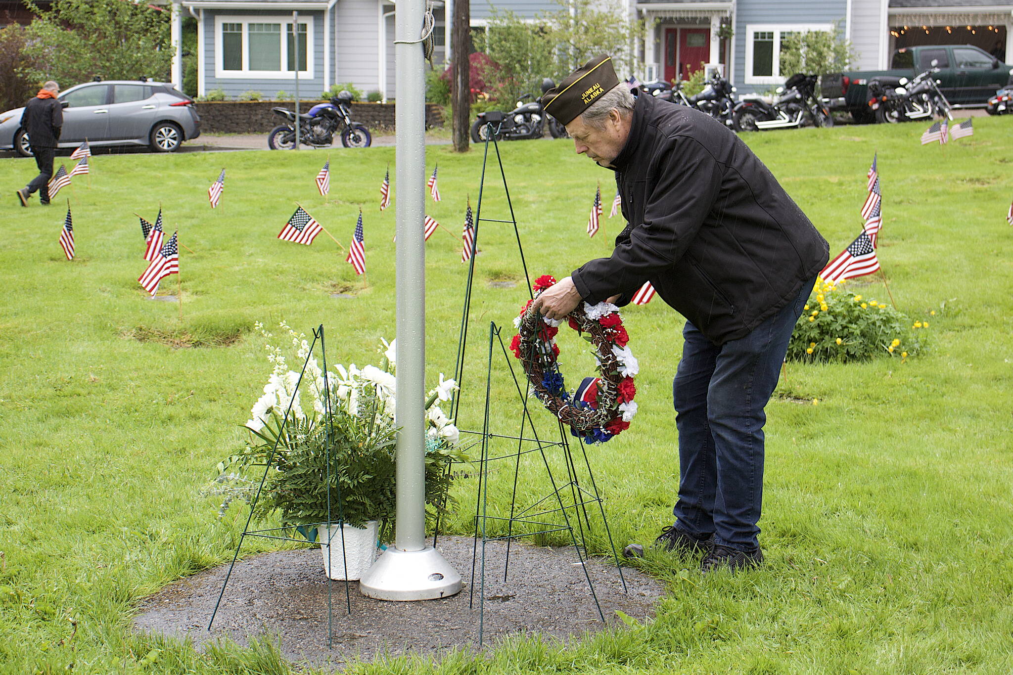 Chuck Caldwell, who served in the Army during the Vietnam War, lays a wreath on behalf of Veterans of Foreign Wars Taku Post 5559 at the base of the flagpole at Evergreen Cemetery in observance of Memorial Day on Monday. (Mark Sabbatini / Juneau Empire)
