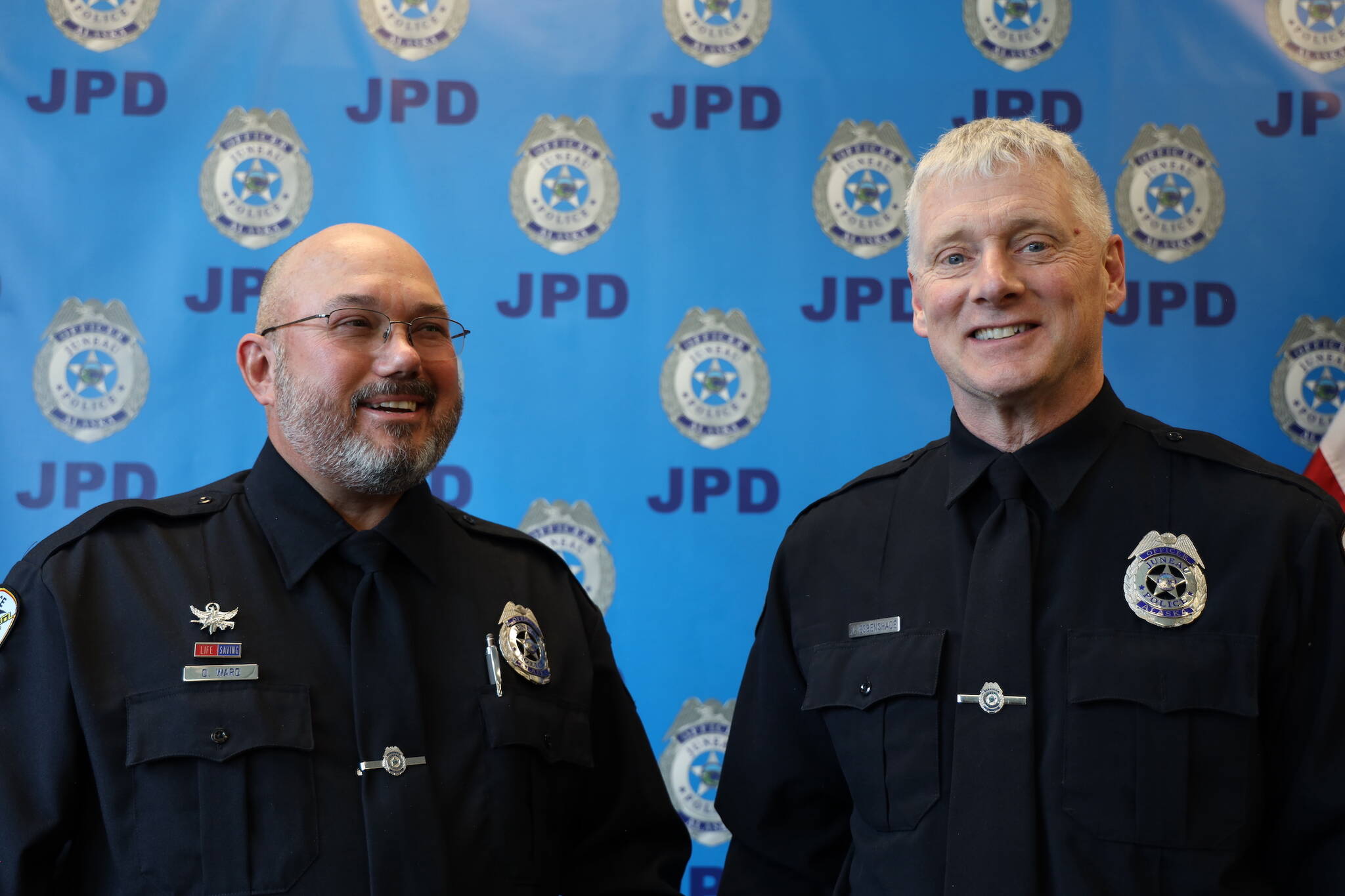 Retiring Juneau Police Department Officers Don Ward (left) and Jim Esbenshade (right) smile for a picture at their joint retirement ceremony on Tuesday afternoon at the Juneau Police Station. (Clarise Larson / Juneau Empire)