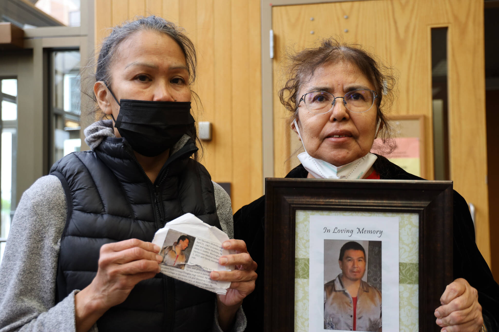 Lavina McKinley, left, and Mary Grant hold photos of their brother Saunders McKinley at the Juneau Courthouse on Wednesday morning. A readiness hearing was held for Tommy Floyd Bowers who has been accused of fatally pushing McKinley out an open second-story window at the Glory Hall in late February 2022. (Clarise Larson / Juneau Empire)