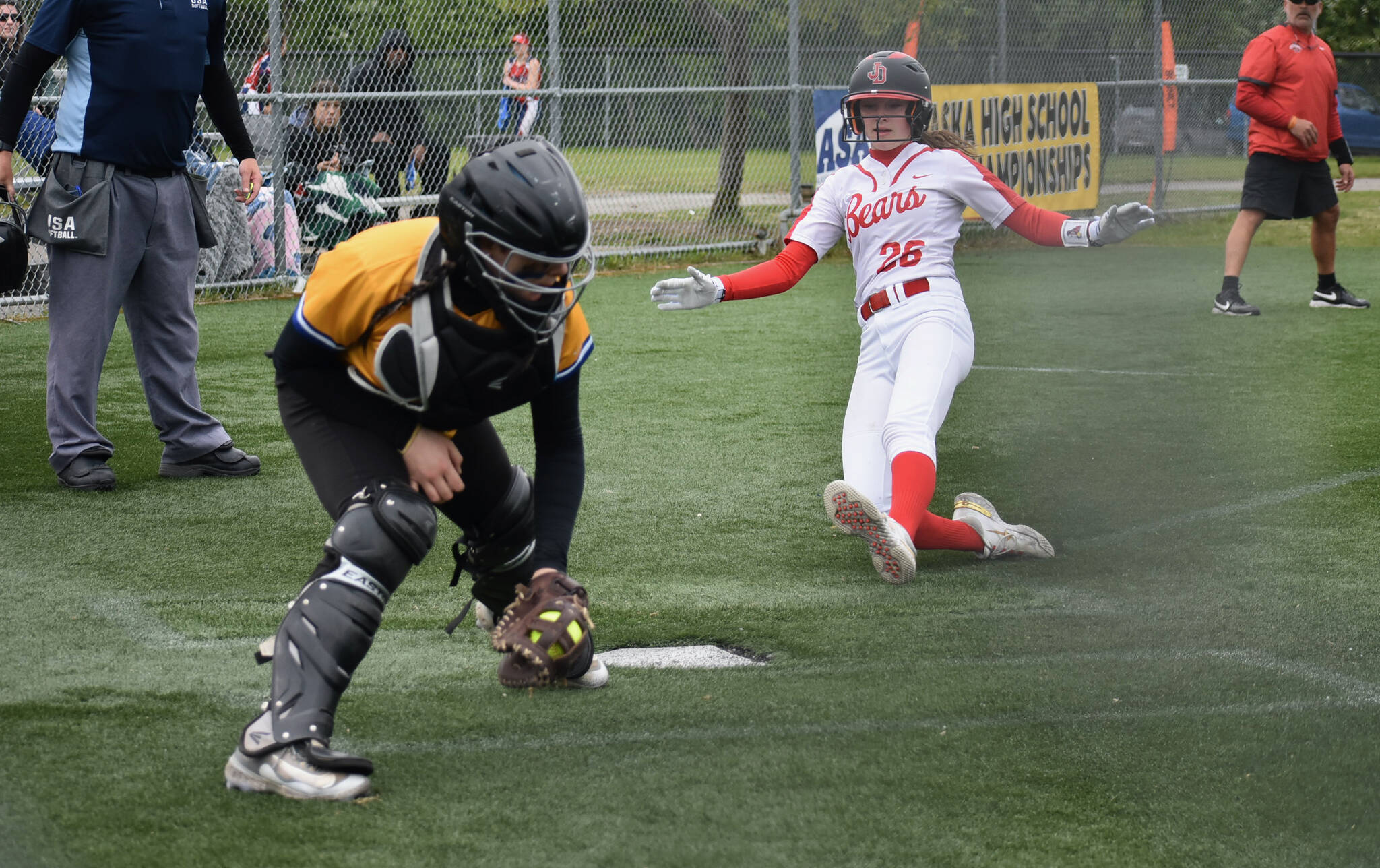 JDHS freshman Gwen Nizich slides into home plate against Kodiak during the Crimson Bears 9-1 win over the Bears on Thursday in the ASAA Division II State Softball Tournament at Anchorage’s Cartee Fields. (Photo Courtesy JDHS Softball)