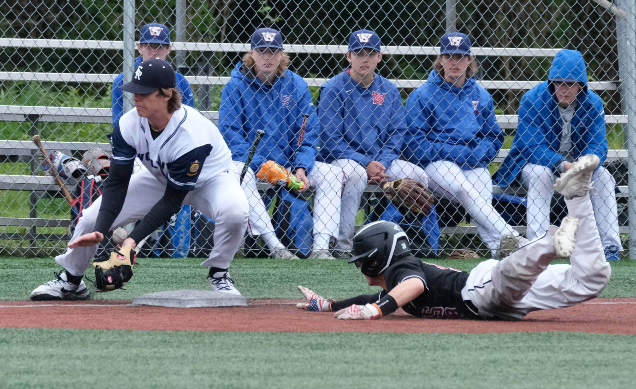 JDHS junior Lamar Blatnick slides safely into third base as Eagle River senior Alexander Mullen bobbles the ball during the Crimson Bears 2-1 loss to the Wolves in an elimination game Friday at the ASAA Division I State Baseball Championships on Sitka’s Moller Field. (Klas Stolpe / Juneau Empire)