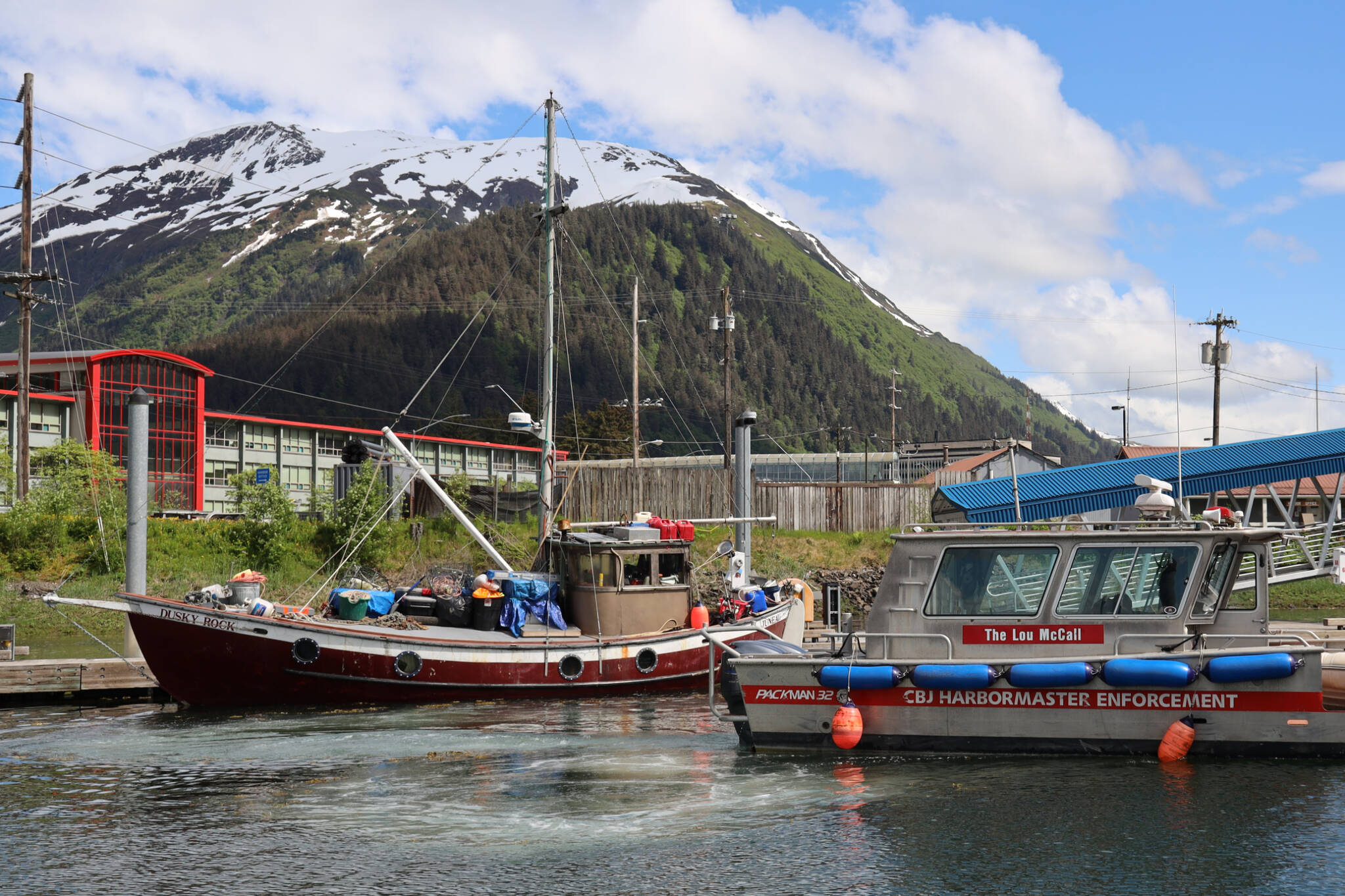 The City and Borough of Juneau Harbormaster Enforcement vessel drives past the Dusky Rock which sits at Aurora Harbor. The vessel was towed there from Sandy beach Friday evening after three people died within a three-day period aboard the vessel while anchored offshore. (Clarise Larson / Juneau Empire)