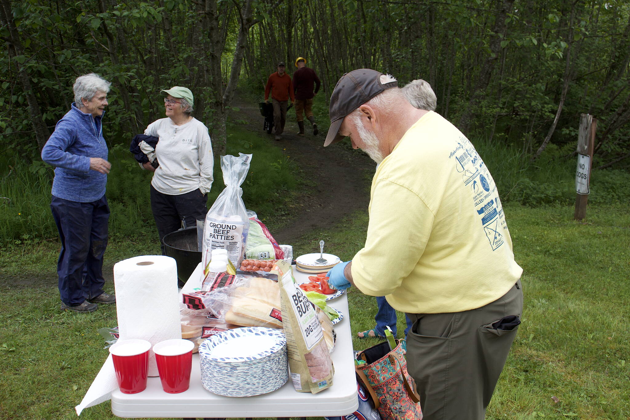 Trail Mix Vice President Ron Bressette prepares fixings for a cookout for workers who spent Saturday morning improving the Kingfisher Pond Loop Trail. (Mark Sabatini / Juneau Empire)