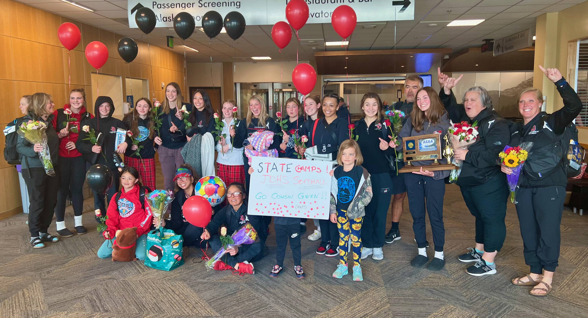 The JDHS Crimson Bears pose with their championship trophy upon arrival at the Juneau airport on Sunday after defeating the Sitka Wolves 6-5 on Saturday on for the ASAA Division II State Softball Championship at Anchorage’s Cartee Fields. (Courtesy Photo /JDHS Softball)