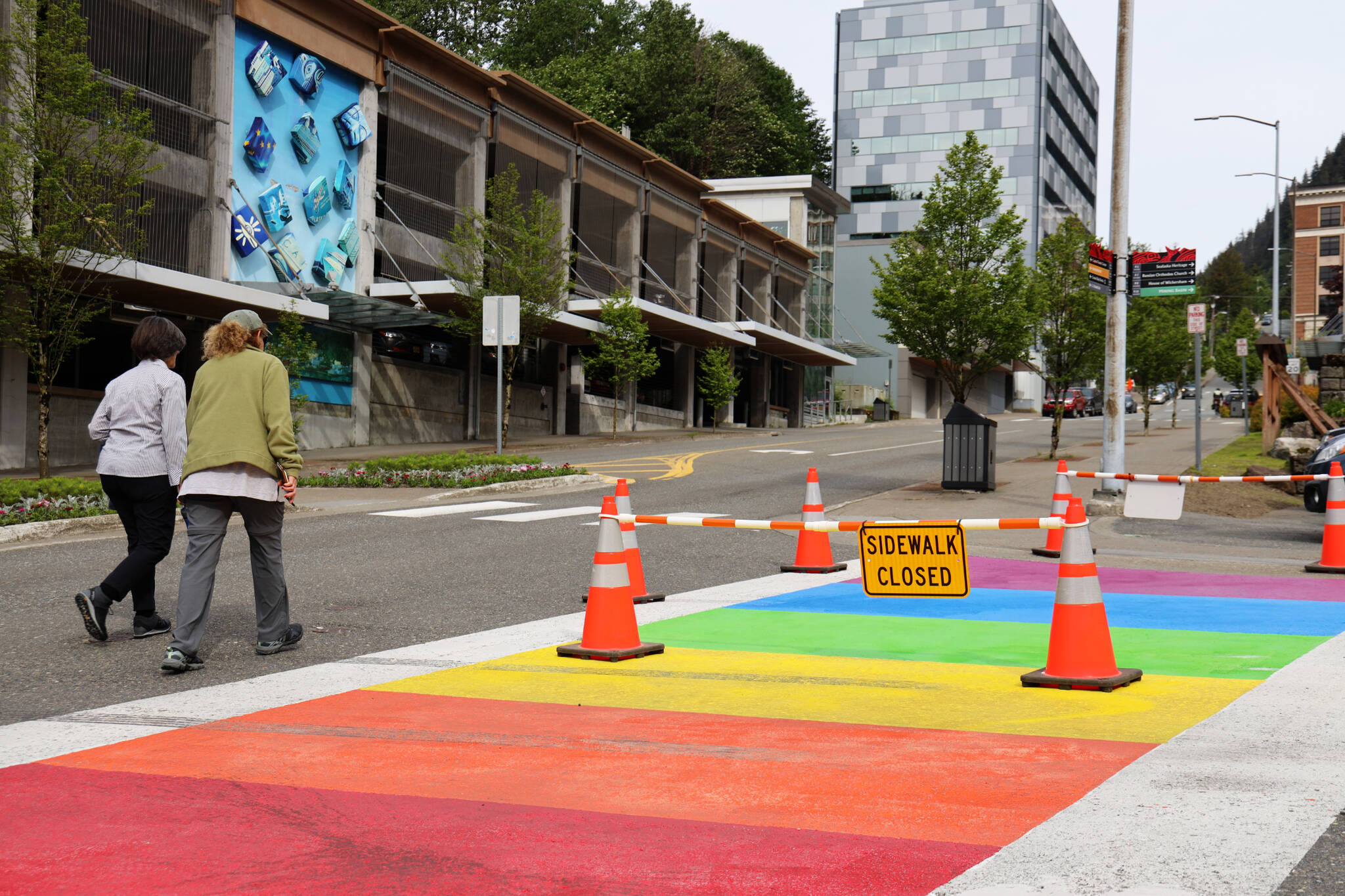 Pedestrians cross by the newly repainted rainbow sidewalk downtown on Thursday morning. (Clarise Larson / Juneau Empire)