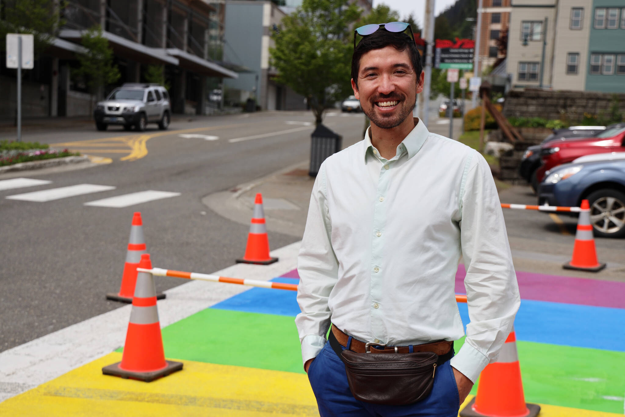 City and Borough of Juneau Assembly member Greg Smith smiles Thursday afternoon while walking across the rainbow crosswalk recently repainted in downtown Juneau. (Clarise Larson / Juneau Empire)