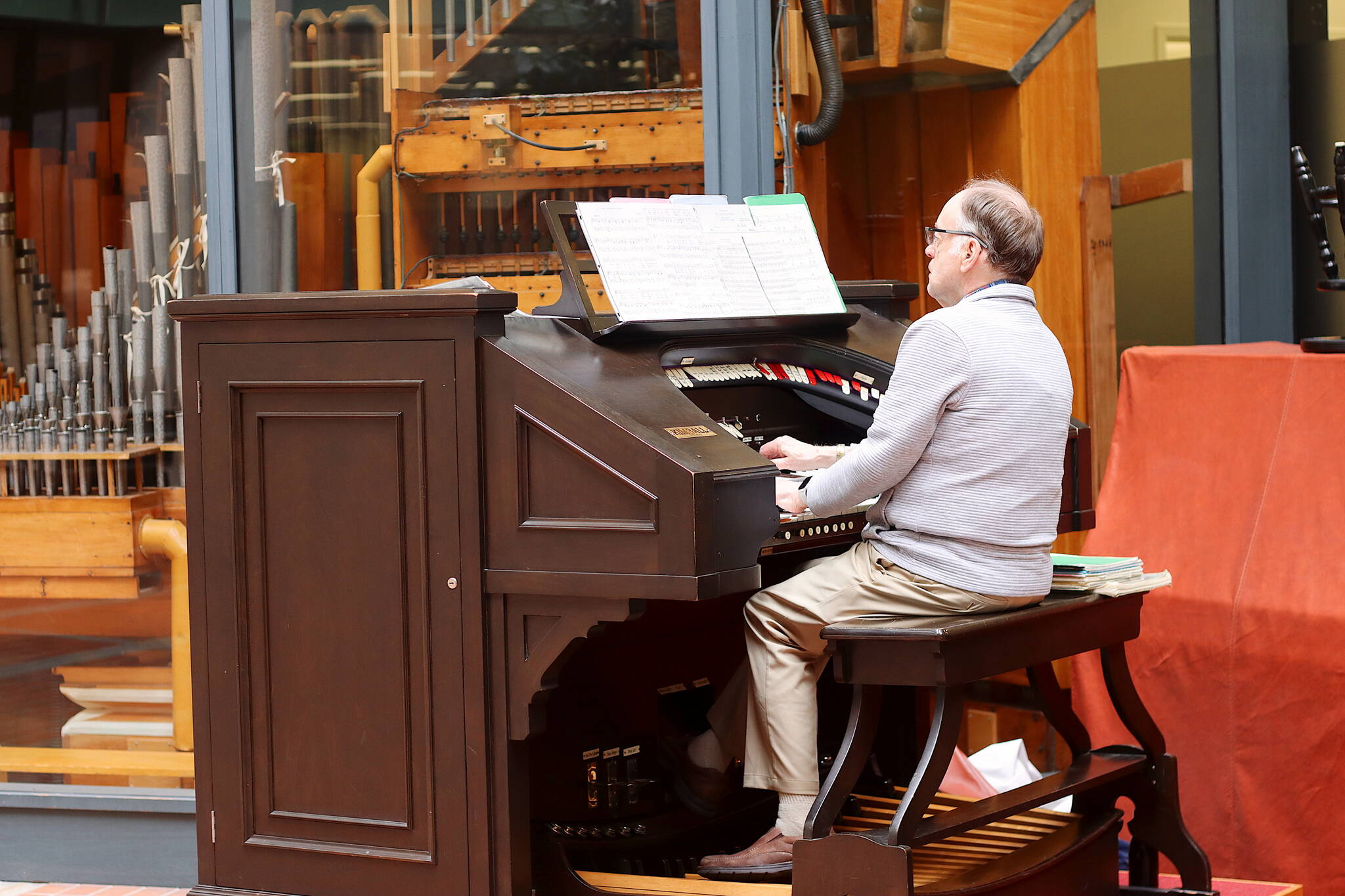 J. Allan MacKinnon performs his first concert in more than three years on the 1928 Kimball Theatre Pipe Organ in the Alaska State Office Building during the noon hour on Friday. Weekly concerts on the instrument were a hallmark of the building for decades, but were halted in early 2020 due to the COVID-19 pandemic. The inactivity left the organ unplayable until technicians from Oregon tuned and restored the instrument the week before MacKinnon’s performance. Additional concerts are scheduled weekly through August. (Mark Sabbatini / Juneau Empire)