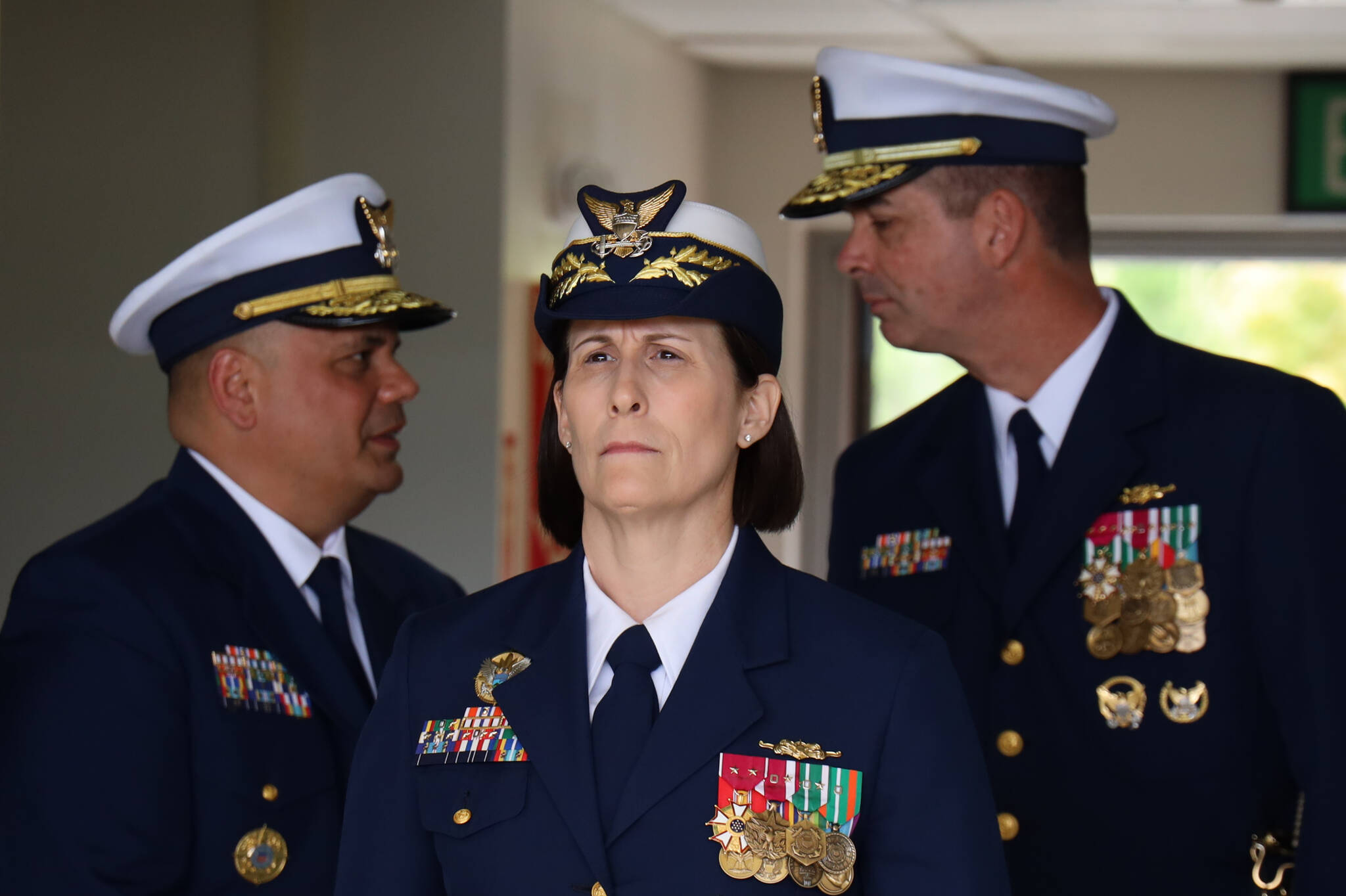 Rear Adm. Megan M. Dean (center) awaits her entrance during a change-of-command Friday in Juneau where she was sworn as the new command of U.S. Coast Guard District 17 at the Alaska Army National Guard Aviation Operating Facility in Juneau. Standing behind to her left is Vice Adm. Andrew J. Tiongson and to her right is outgoing Rear Adm. Nathan A. Moore. (Clarise Larson / Juneau Empire)