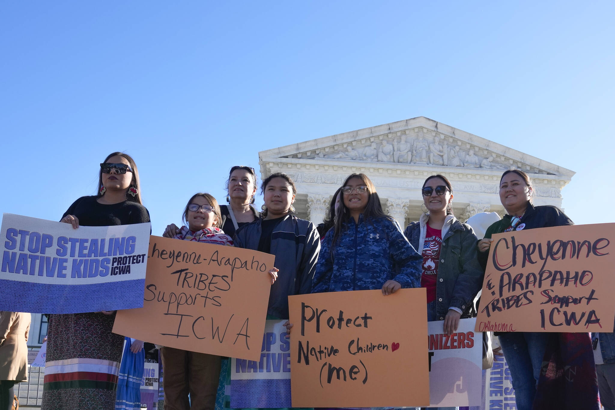 Demonstrators stand outside of the U.S. Supreme Court, as the court hears arguments over the Indian Child Welfare Act, Nov. 9, 2022, in Washington. The Supreme Court on Thursday preserved the 1978 Indian Child Welfare Act, which gives preference to Native American families in foster care and adoption proceedings of Native children, rejecting a broad attack from Republican-led states and white families who argued it is based on race. (AP Photo/Mariam Zuhaib, File)