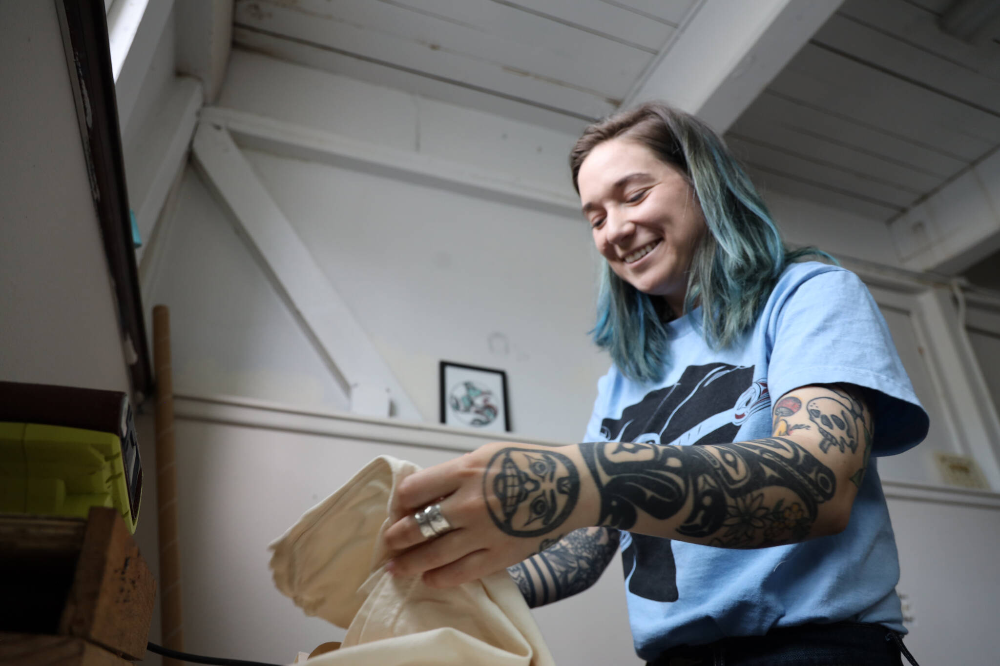 Chloey Cavanaugh, owner of Black and White Raven Co., folds a shirt at her downtown studio Monday morning. Cavanaugh’s company is an LGBTQ+ and Indigenous small business based in Juneau. (Clarise Larson / Juneau Empire)