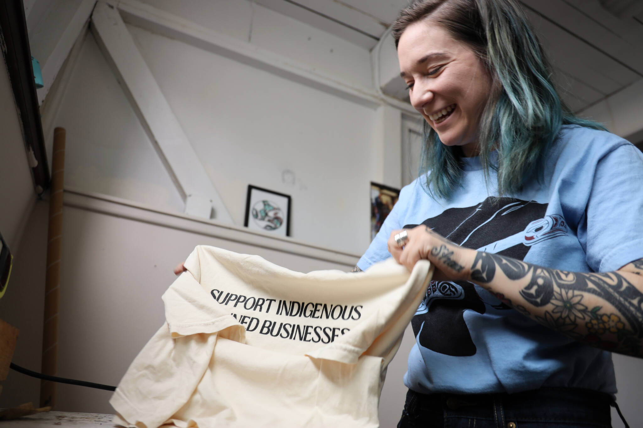 Chloey Cavanaugh, owner of Black and White Raven Co., folds a shirt at her downtown studio Monday morning. Cavanaugh’s company is an LGBTQ+ and Indigenous small business based in Juneau. (Clarise Larson / Juneau Empire)