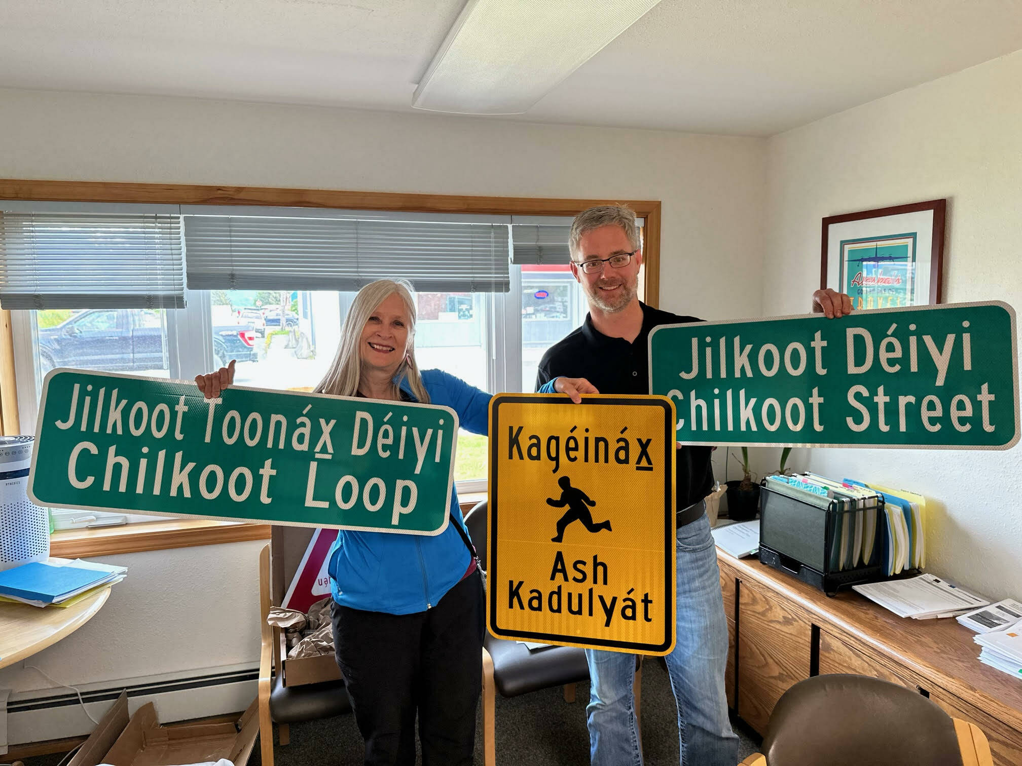Juneau State Rep. Andi Story and Haines Borough Mayor Douglas Olerud smile for a photo while holding the borough’s first batch of Lingít street signs in early June. (Courtesy / Katie Koester)