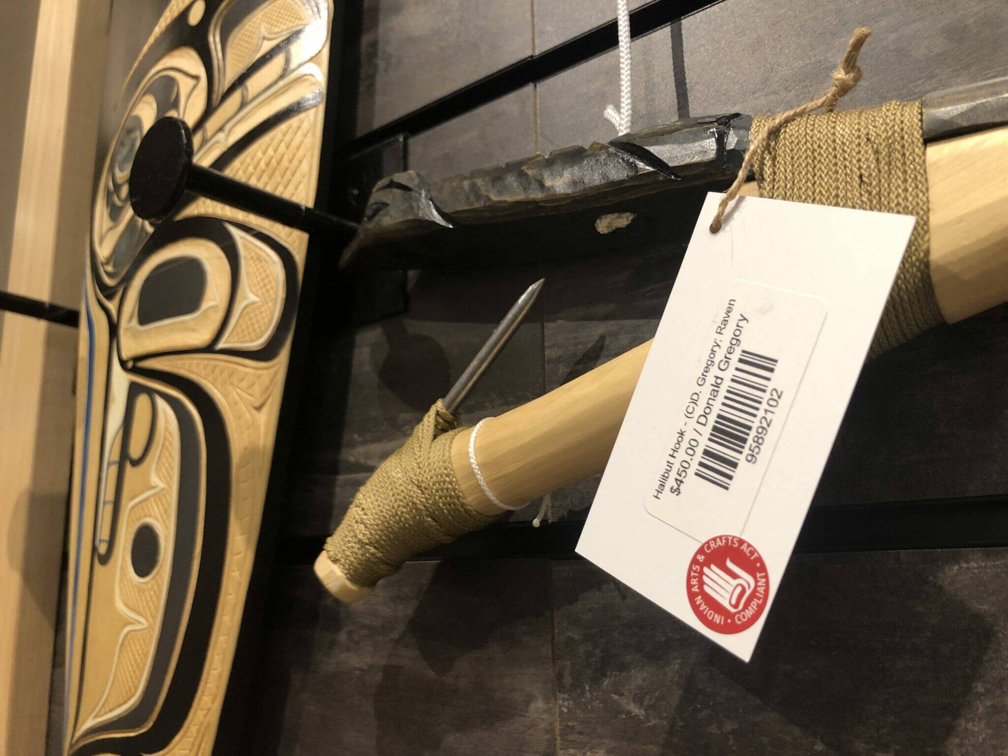 Artwork for sale at the Sealaska Heritage Institute shop on Friday bears a label declaring it compliant with the Indian Arts and Crafts Act. The federal government has filed several recent cases in Alaska for violations of the act. (Photo by James Brooks/Alaska Beacon)