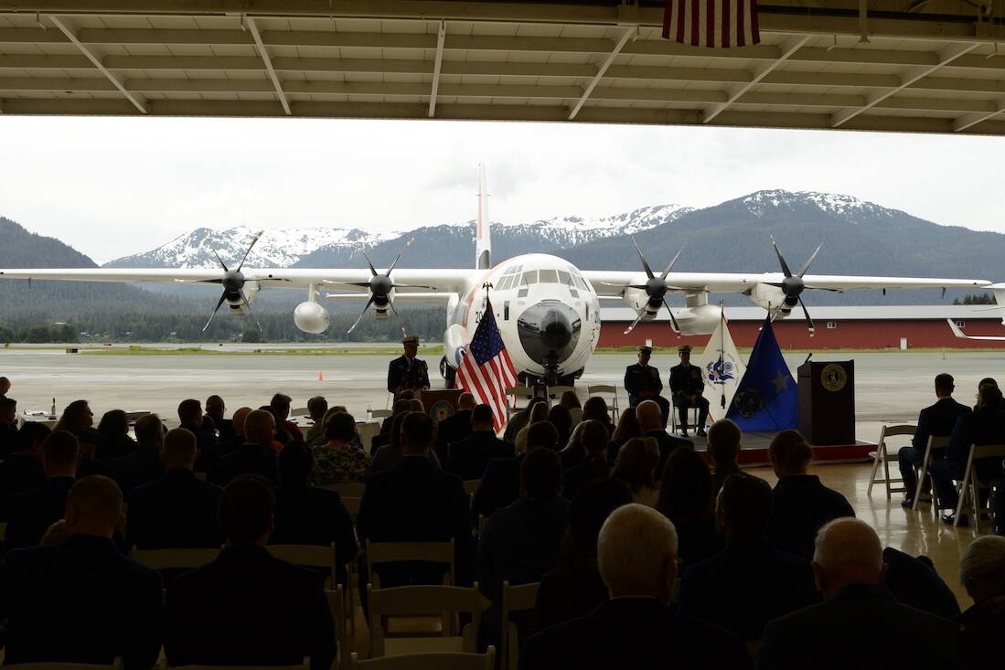 Coast Guard officials are silhouetted by rescue aircraft during a change of command ceremony on June 9 in Juneau. (Photo by James Brooks/Alaska Beacon)