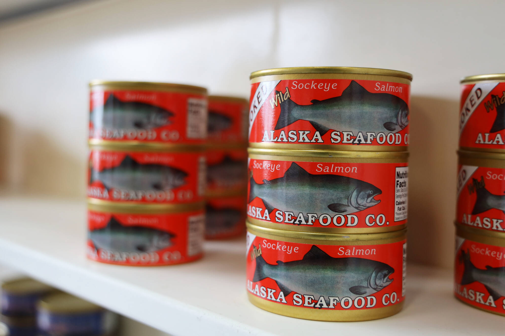 Cans of smoked sockeye salmon line the shelves at the Alaska Seafood Company facility in Lemon Creek. The Central Council of the Tlingit and Haida Indian Tribes of Alaska recently purchased the company and will begin operations by beginning of July, the tribe’s president told the Empire. (Clarise Larson / Juneau Empire)