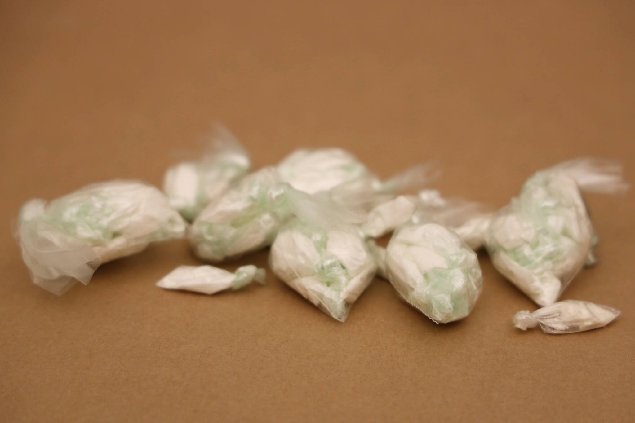 This March 10 photo shows drugs seized by police. A Juneau man was arrested Thursday on felony drug charges and police seized several types of drugs with a street value of $32,650, plus nearly $50,000 in cash. (Clarise Larson / Juneau Empire File)