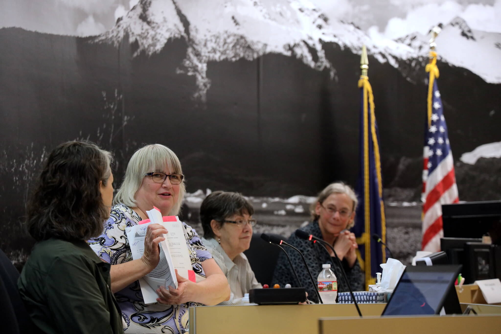 Mayor Beth Weldon flips through an Assembly meeting agenda to give a glimpse at the workload potential candidates for the upcoming election can expect if elected into local office. Weldon was joined by Kristin Bartlett, chief of staff for the Juneau School District (left), Juneau School Board President Deedie Sorenson (middle right) and Mila Cosgrove, former deputy city manager (right), at the City and Borough of Juneau’s annual “How To Run For Local Office” workshop Saturday. (Clarise Larson / Juneau Empire)