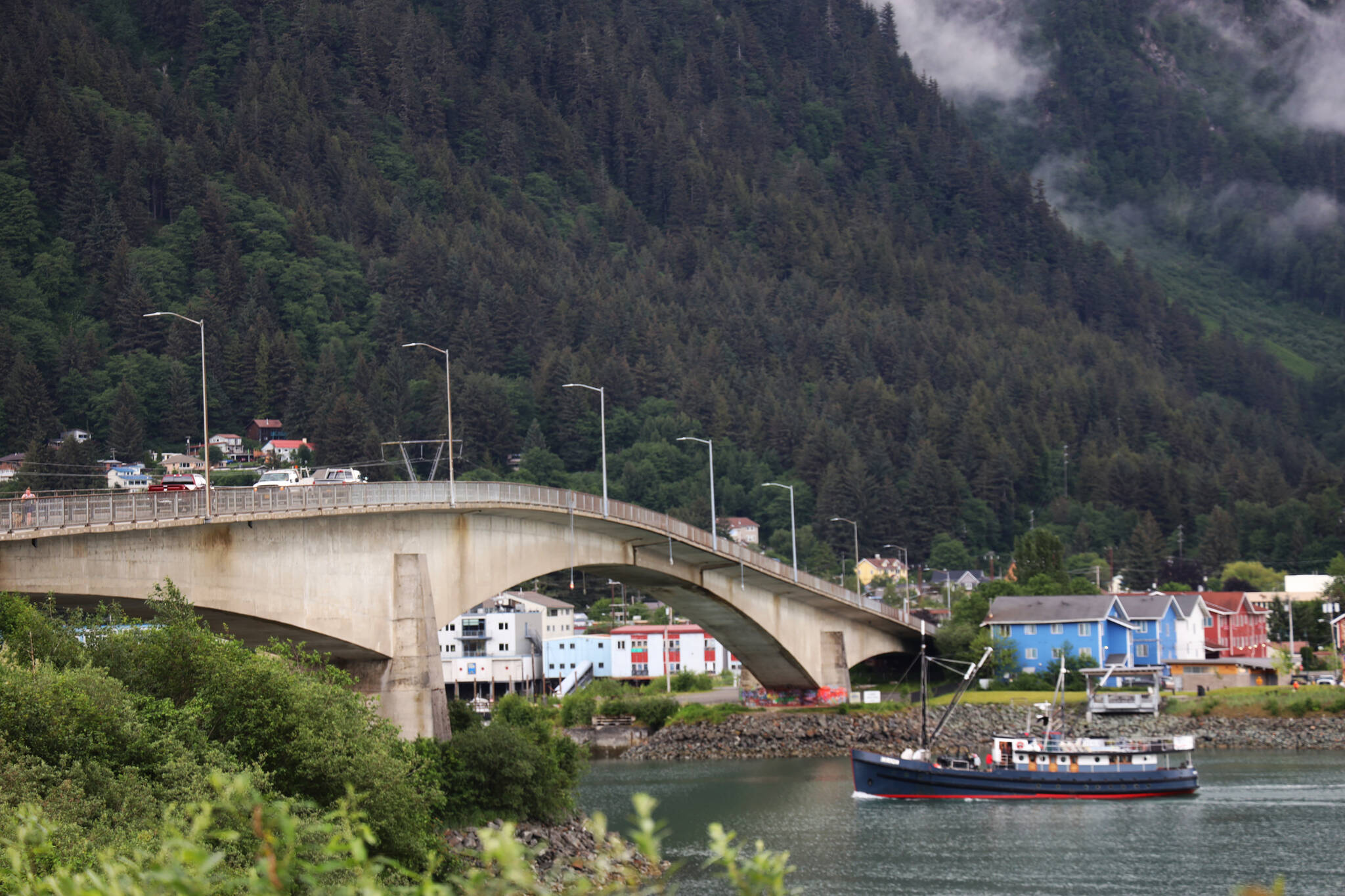 A boat crosses under the bridge between the Juneau mainland and Douglas Island on Wednesday morning. (Clarise Larson / Juneau Empire)