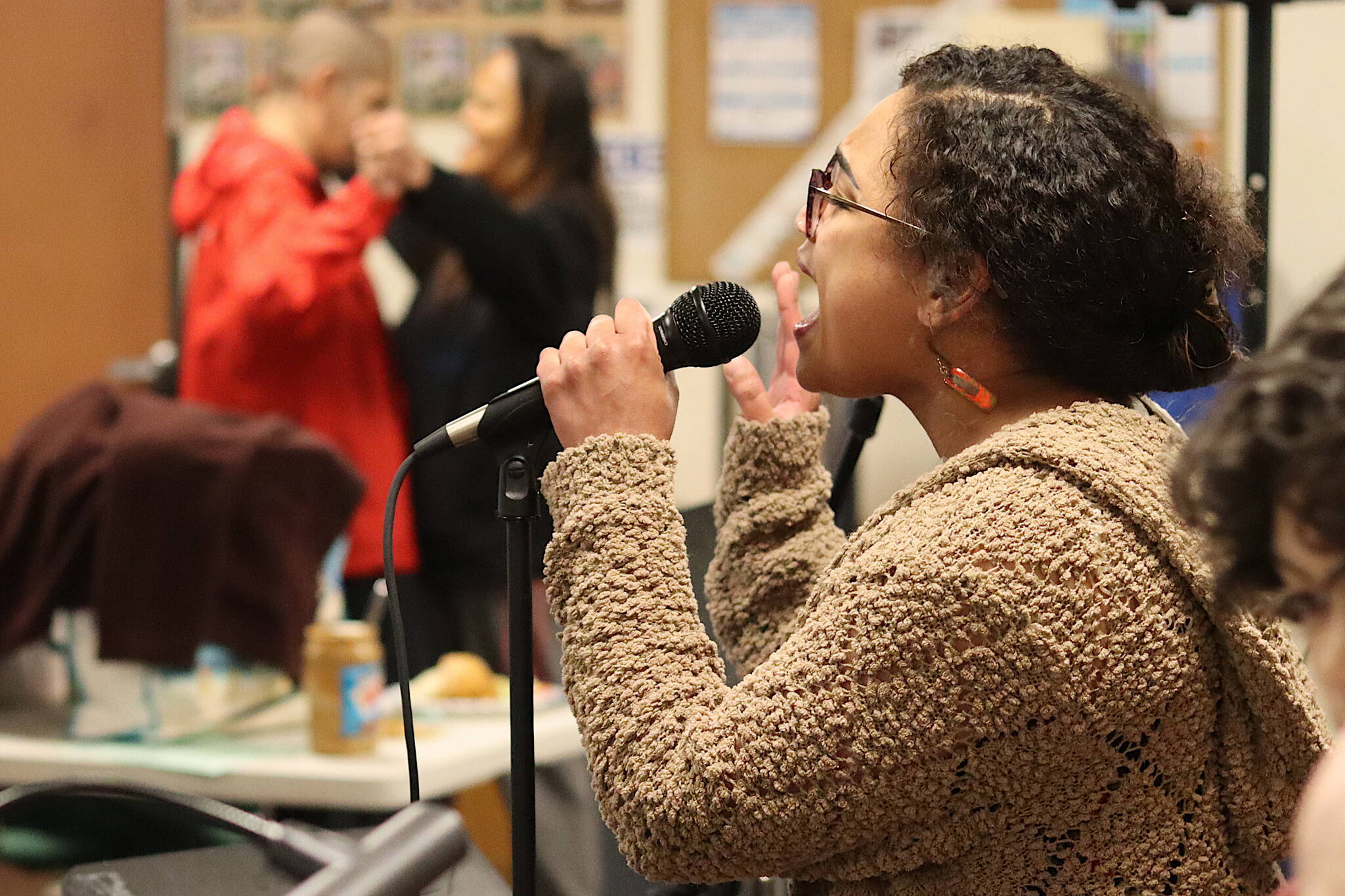 Salissa Thole sings a pop song while a couple dances in the background during a “Neighborhood Cabaret” show at the Glory Hall on Thursday evening. The shows being performed at various location in Juneau are the first of three productions during this year’s Alaska Theater Festival. (Mark Sabbatini / Juneau Empire)
