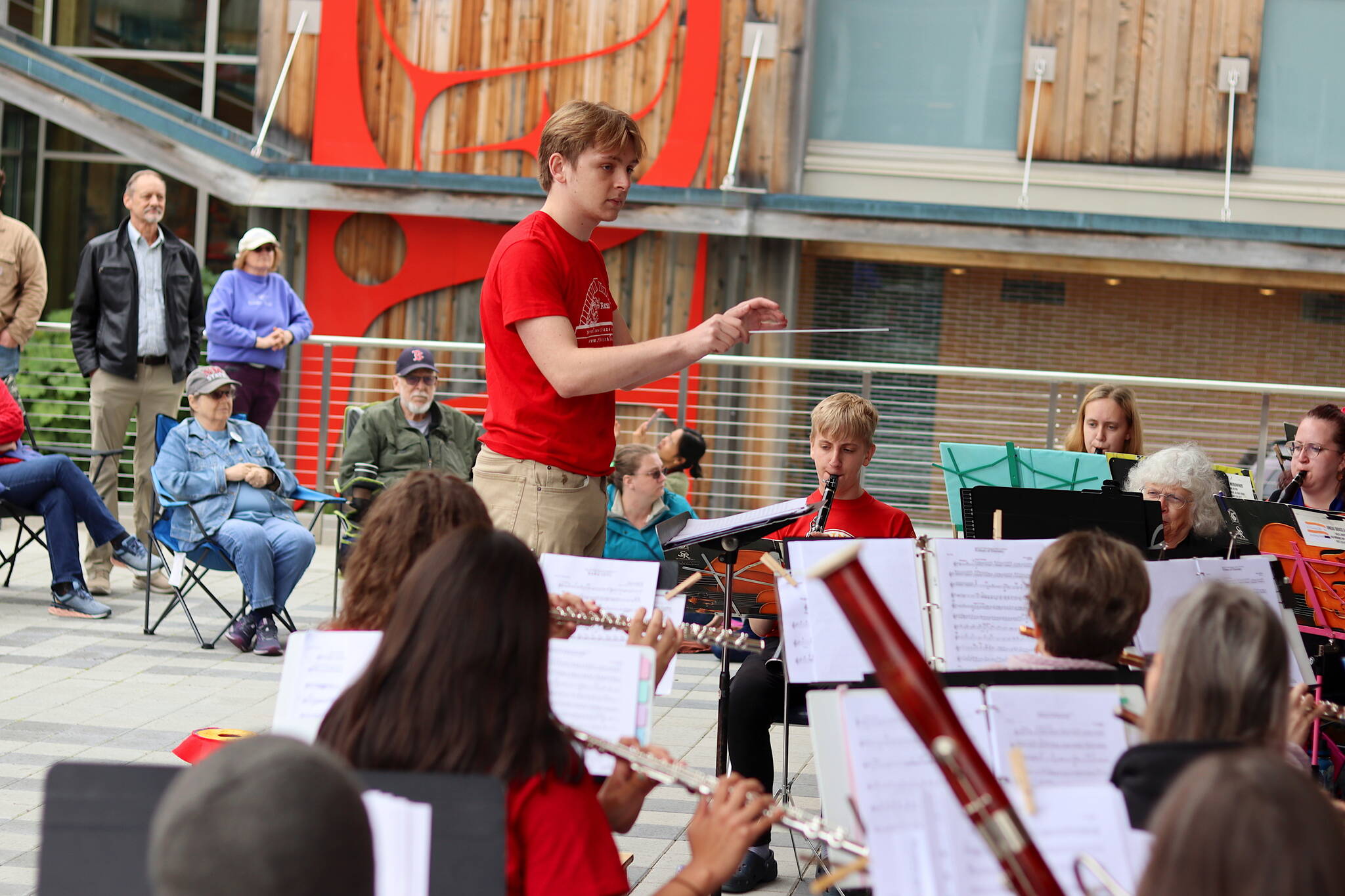 Patrick Jimmerson, a Juneau resident studying music at Loyola University in New Orleans, guest conducts a song by the Juneau Volunteer Marching Band on Sunday at Sealaska Heritage Plaza. (Mark Sabbatini / Juneau Empire)
