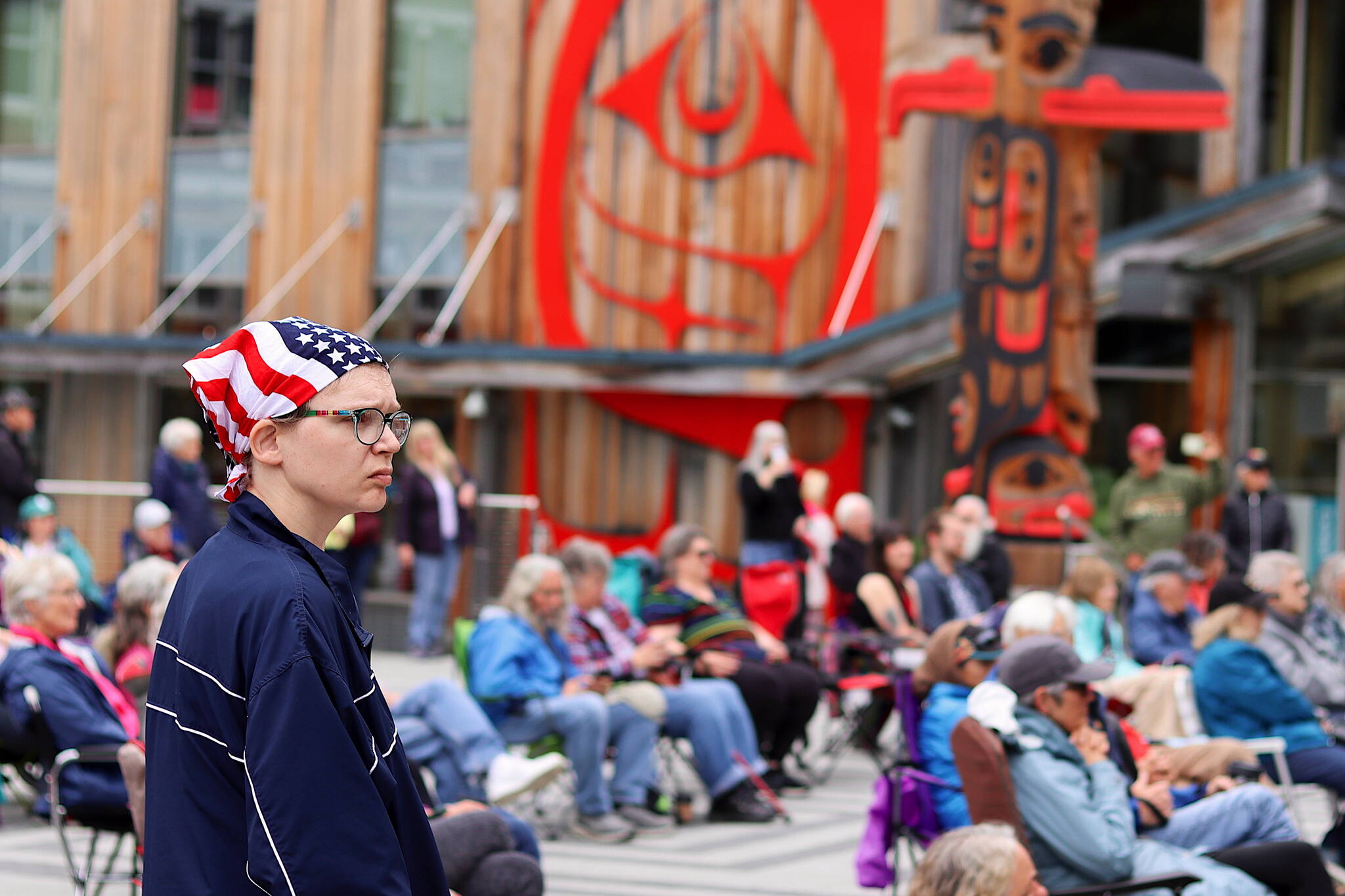 Tammi Birch watches an Independence Day Concert by the Juneau Volunteer Marching Band on Sunday at Sealaska Heritage Plaza. (Mark Sabbatini / Juneau Empire)