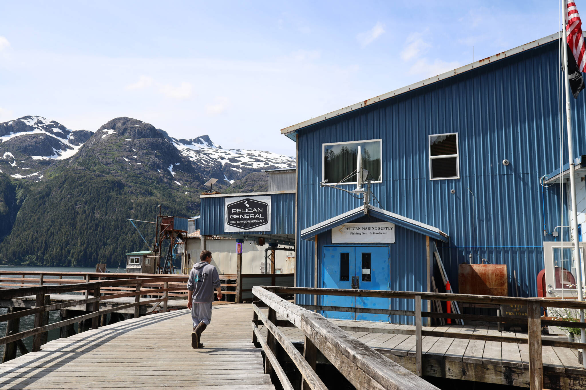 A resident walks to the entrance of the newly opened Pelican General, the town’s first general store to open in 15 years. A grand opening potluck was hosted Monday to celebrate its opening. (Clarise Larson / Juneau Empire)