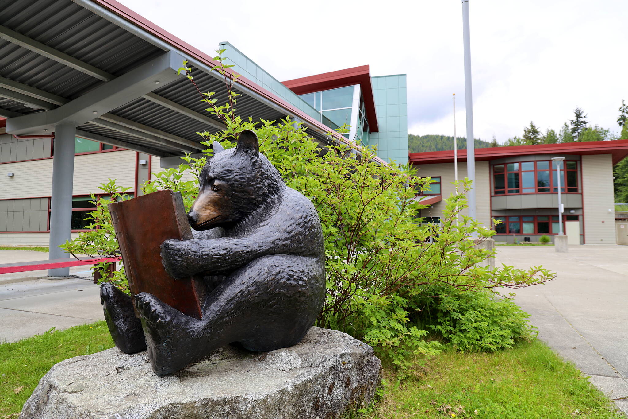 A sculpture of a bear reading a book is seen in front of Auke Bay Elementary School on Wednesday. (Clarise Larson / Juneau Empire)