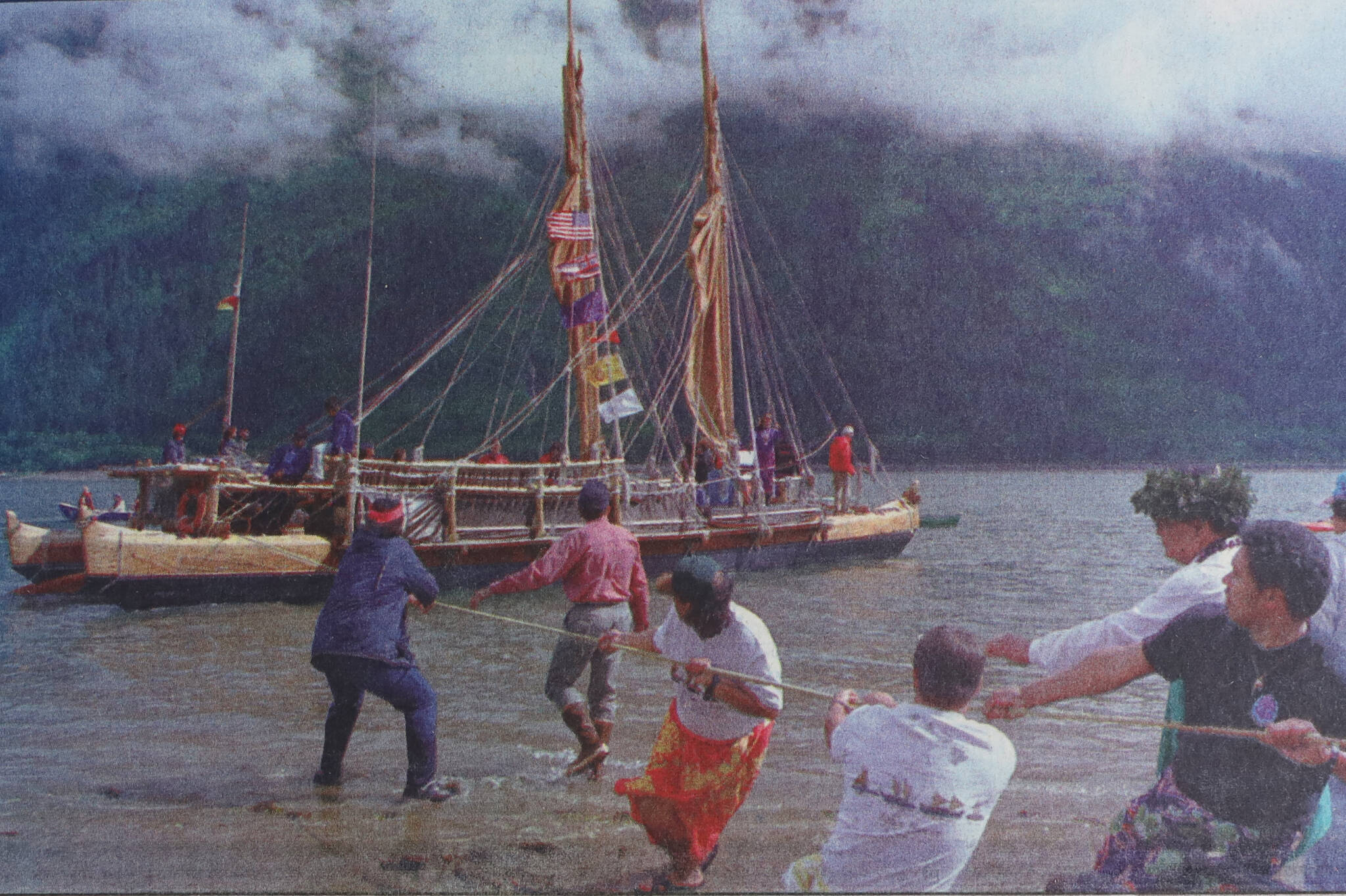 Members of Juneau’s Hawaiian and Native communities help pull the Hawai’iloa closer to shore at Sandy Beach on July 14, 1995. (Brian Wallace / Juneau Empire Archives)