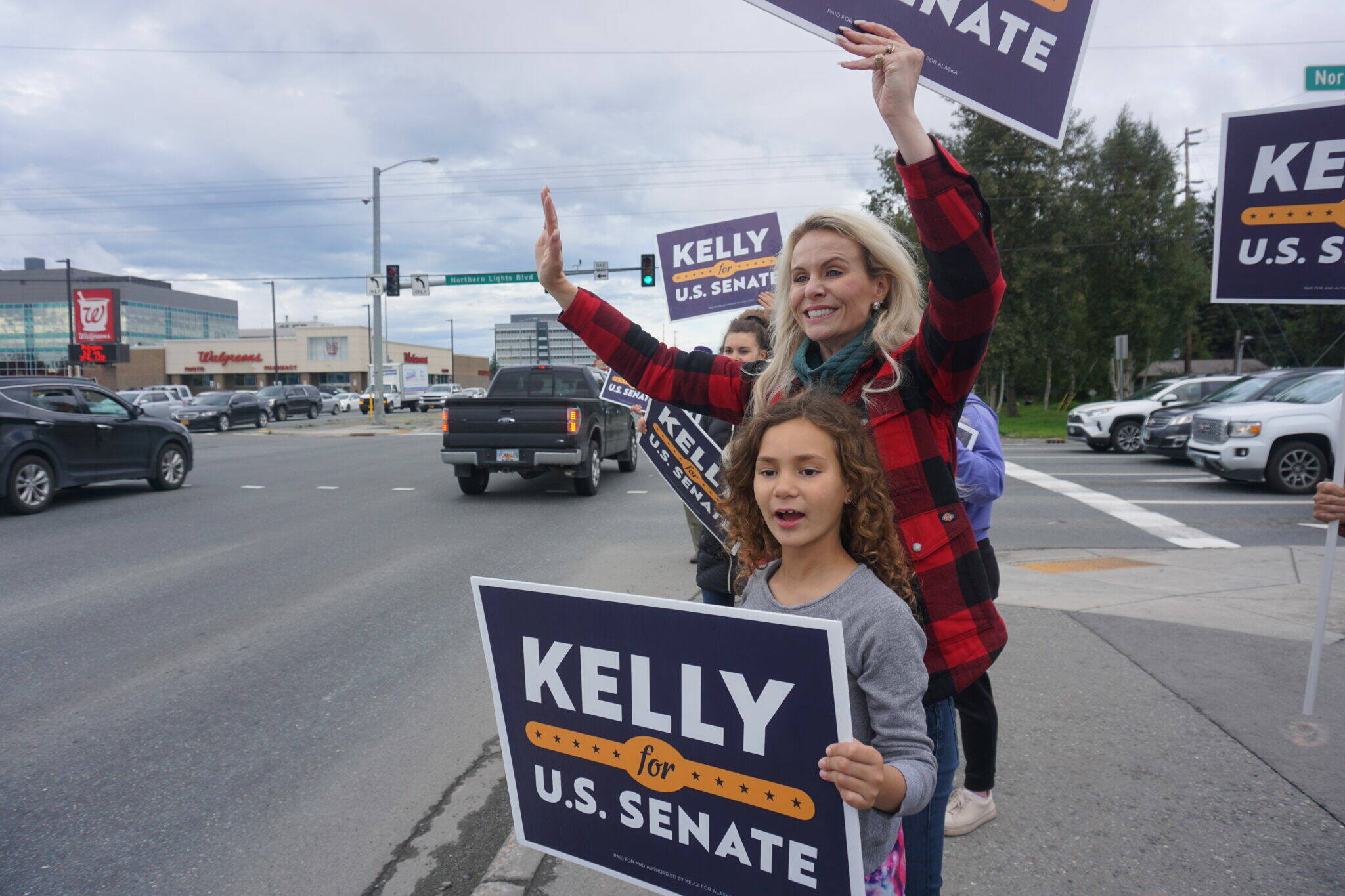 Kelly Tshibaka waves at passing motorists in Midtown Anchorage on Aug. 16, 2022. The former U.S. Senate candidate, now head of a nonprofit opposing ranked choice voting, is the subject of a new campaign complaint. (Photo by Yereth Rosen/Alaska Beacon)