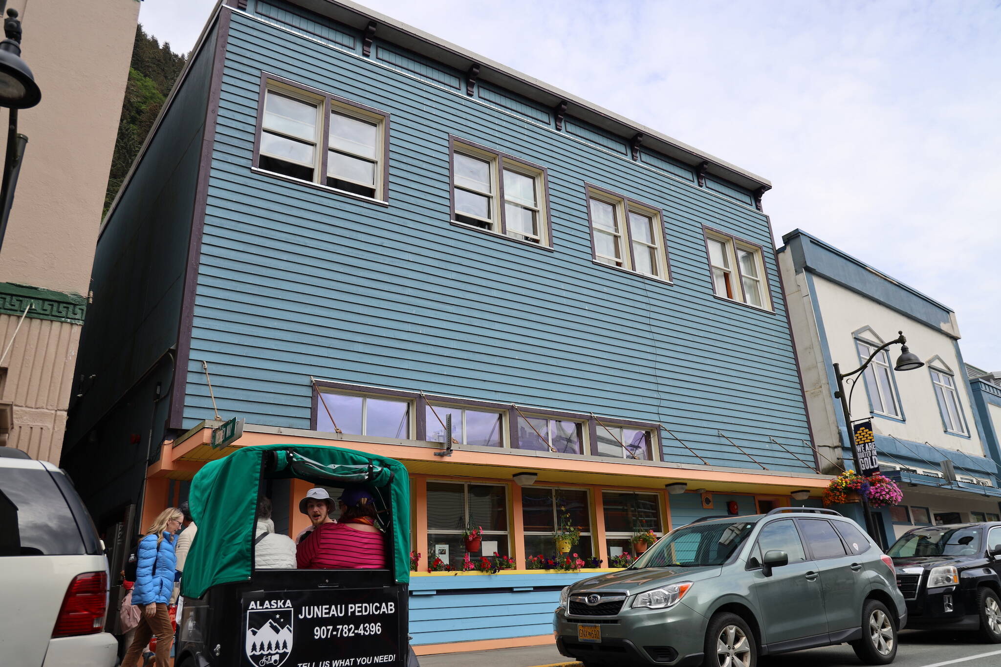 A cycle rickshaw and cars park outside the front of the Glory Hall’s former downtown homeless shelter Tuesday evening. The building is slated to begin its transformation into seven affordable housing units and additional commercial use space in mid-October. (Clarise Larson / Juneau Empire)