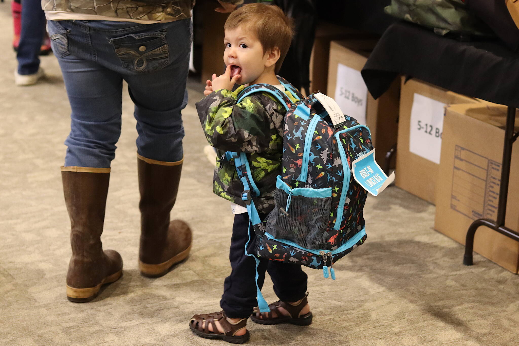 Michael Dunigan, 2, wears a backpack meant for his five-year-old brother during the Central Council of the Tlingit and Haida Indian Tribes of Alaska’s annual backpack distribution at Elizabeth Peratrovich Hall on Saturday.