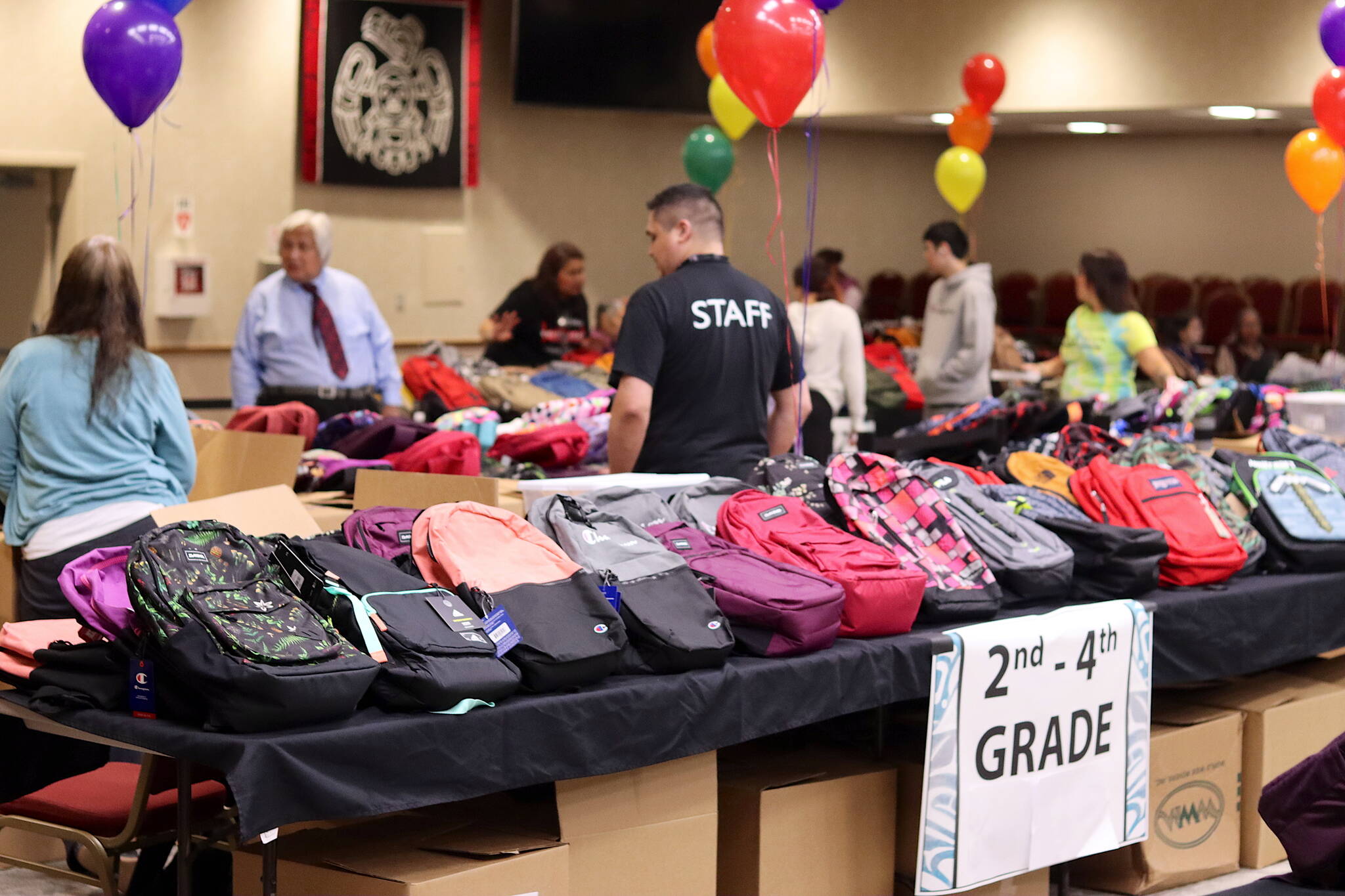 Backpacks designated for specific grade levels are shown on tables at Elizabeth Peratrovich Hall during the Central Council of the Tlingit and Haida Indian Tribes of Alaska’s annual backpack distribution Saturday. (Mark Sabbatini / Juneau Empire)