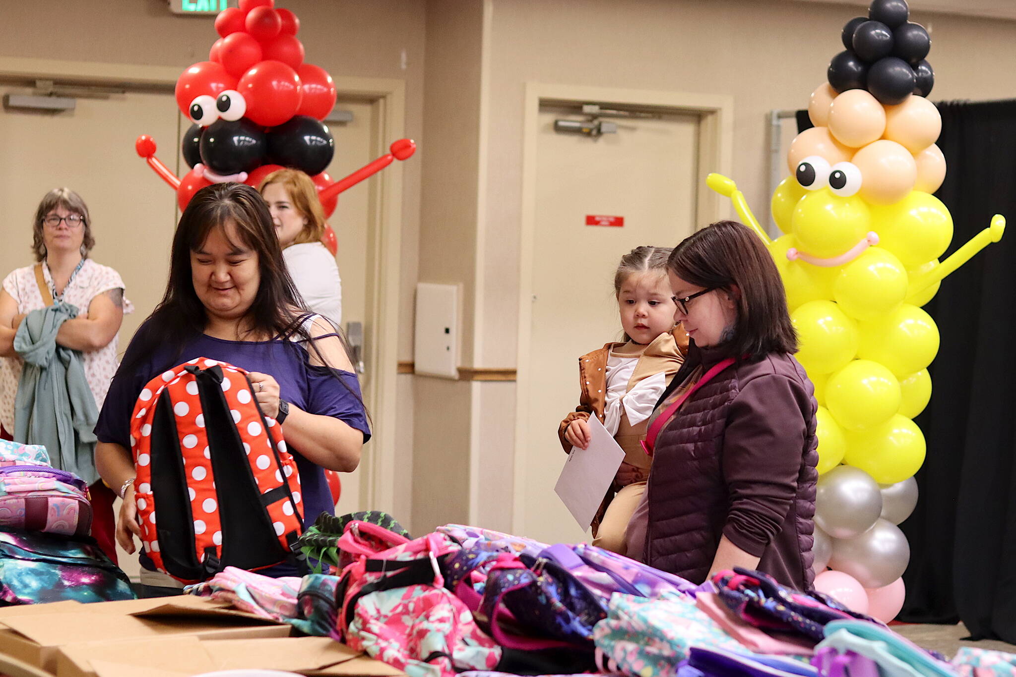 Photos by Mark Sabbatini / Juneau Empire
Alicia Bagoyo, right and her daughter, Madalyn, look for a pre-kindergarten backpack with assistance from staff member Julie James during the Central Council of the Tlingit and Haida Indian Tribes of Alaska’s annual backpack distribution at Elizabeth Peratrovich Hall on Saturday.