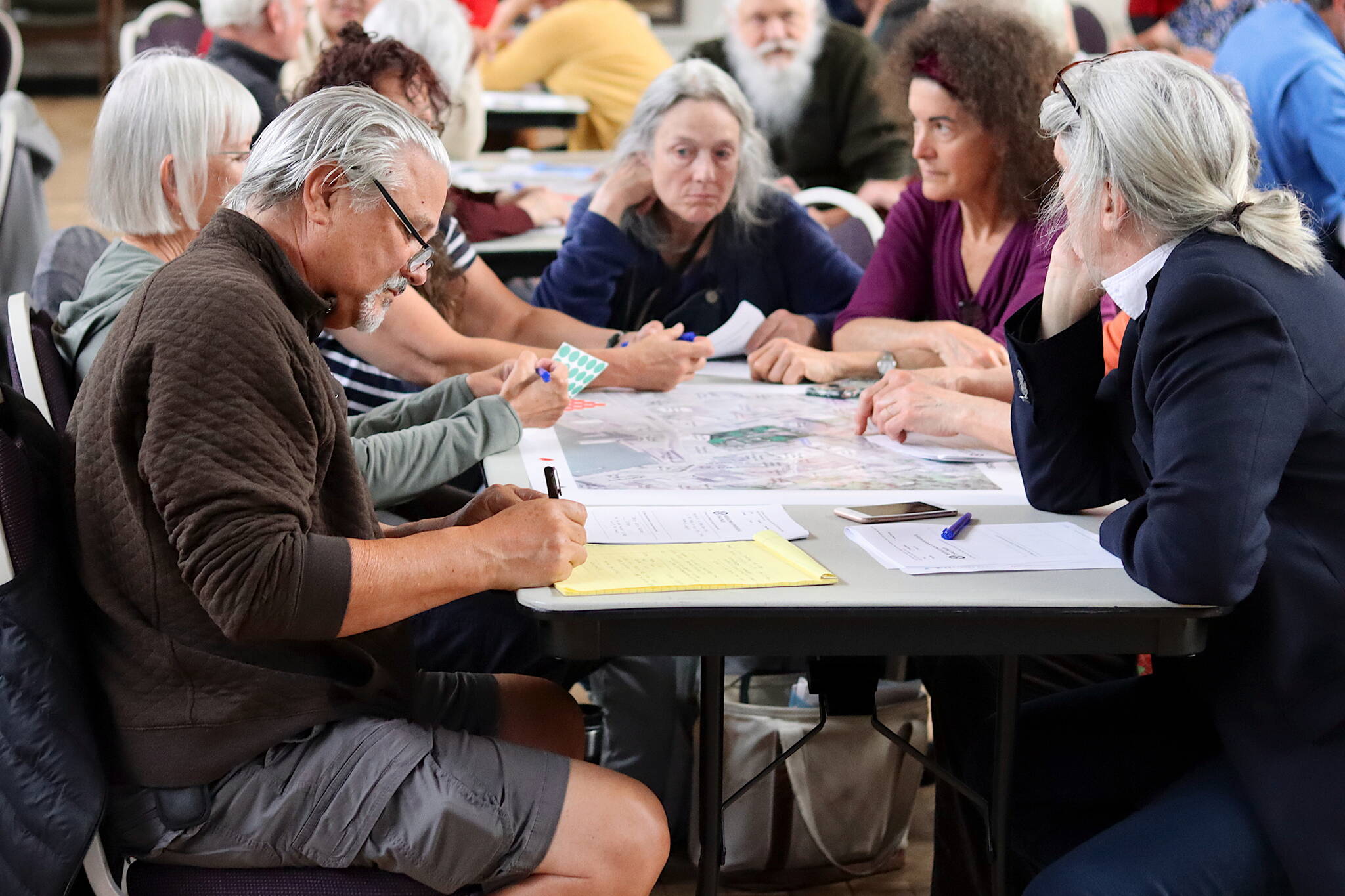 Mark Whitman, a Douglas resident, joins others in offering opinions about the future of Telephone Hill during an open house at the Juneau Arts and Culture Center on Wednesday. (Mark Sabbatini / Juneau Empire)