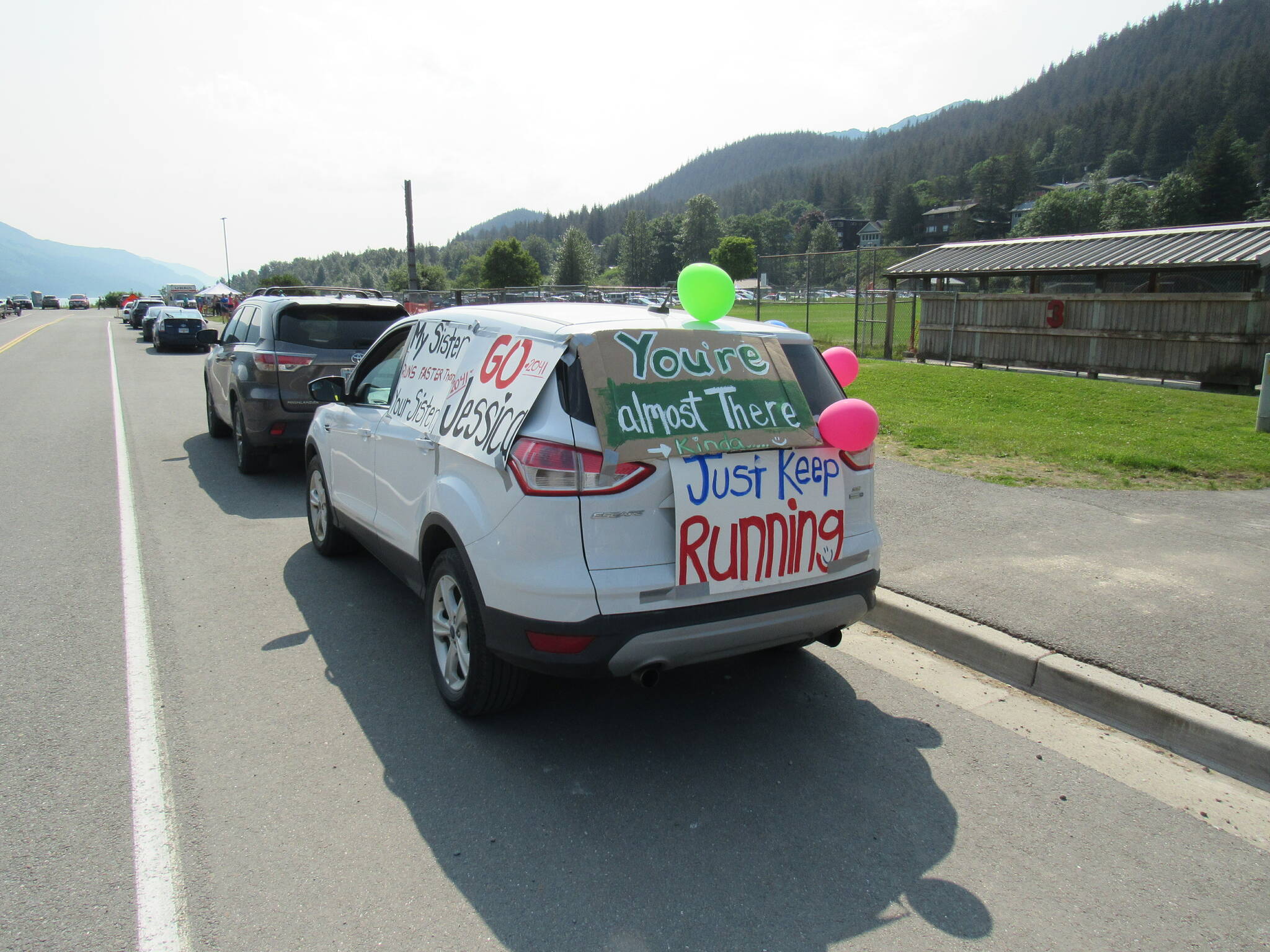 A car offers encouragement to a participant in the Juneau Marathon and Half-Marathon on Saturday at Savikko Park. (Photo courtesy of Juneau Trail and Road Runners)