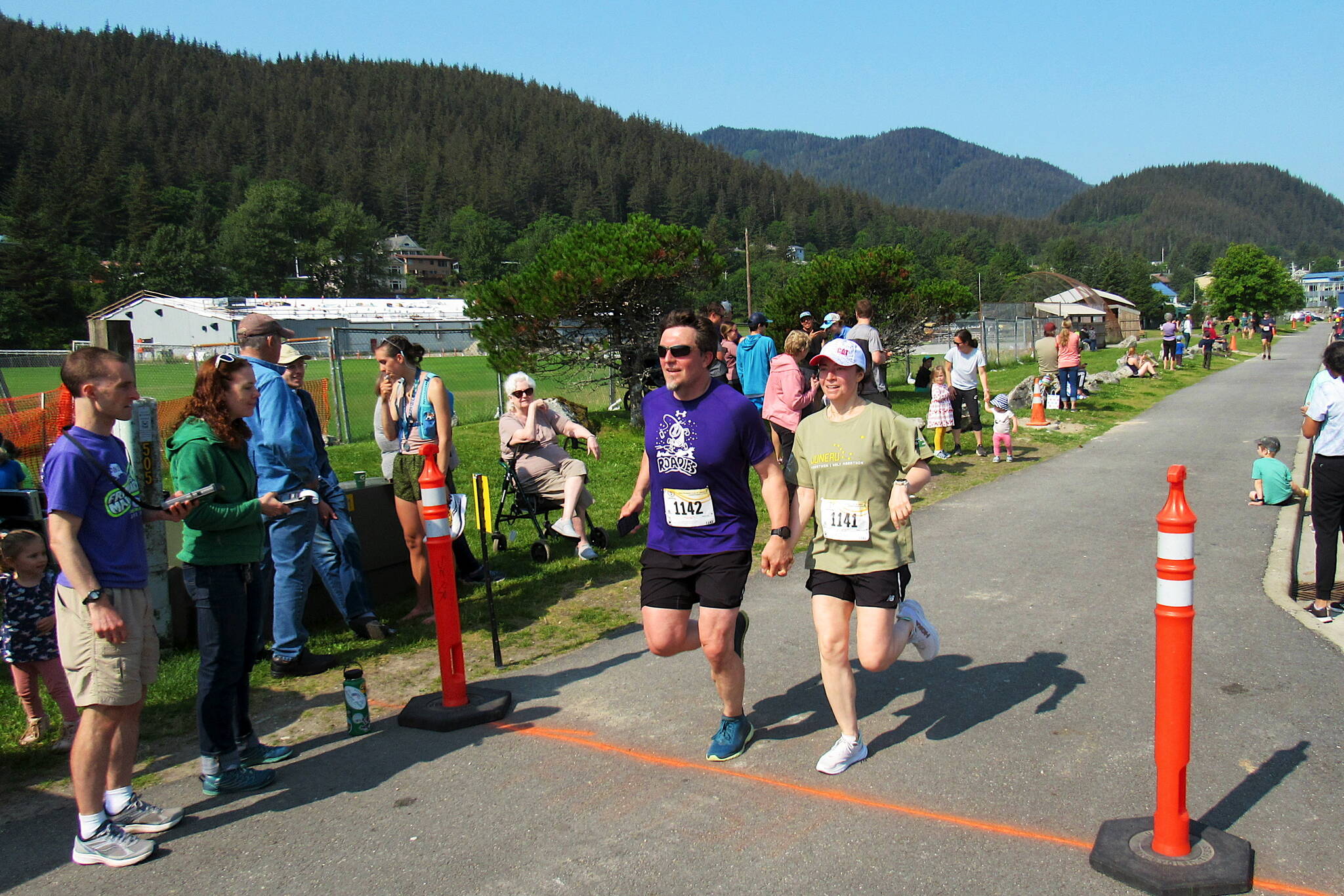 Samuel and Justine Carlisle, a couple from Asheville, North Carolina, cross the finish line of the Juneau Half Marathon on Saturday at Savikko Park. Organizers of the event, which includes full and half marathons, estimate about half of the participants are from outside Juneau because it is considered a "destination" race. (Photo courtesy of Juneau Trail and Road Runners)