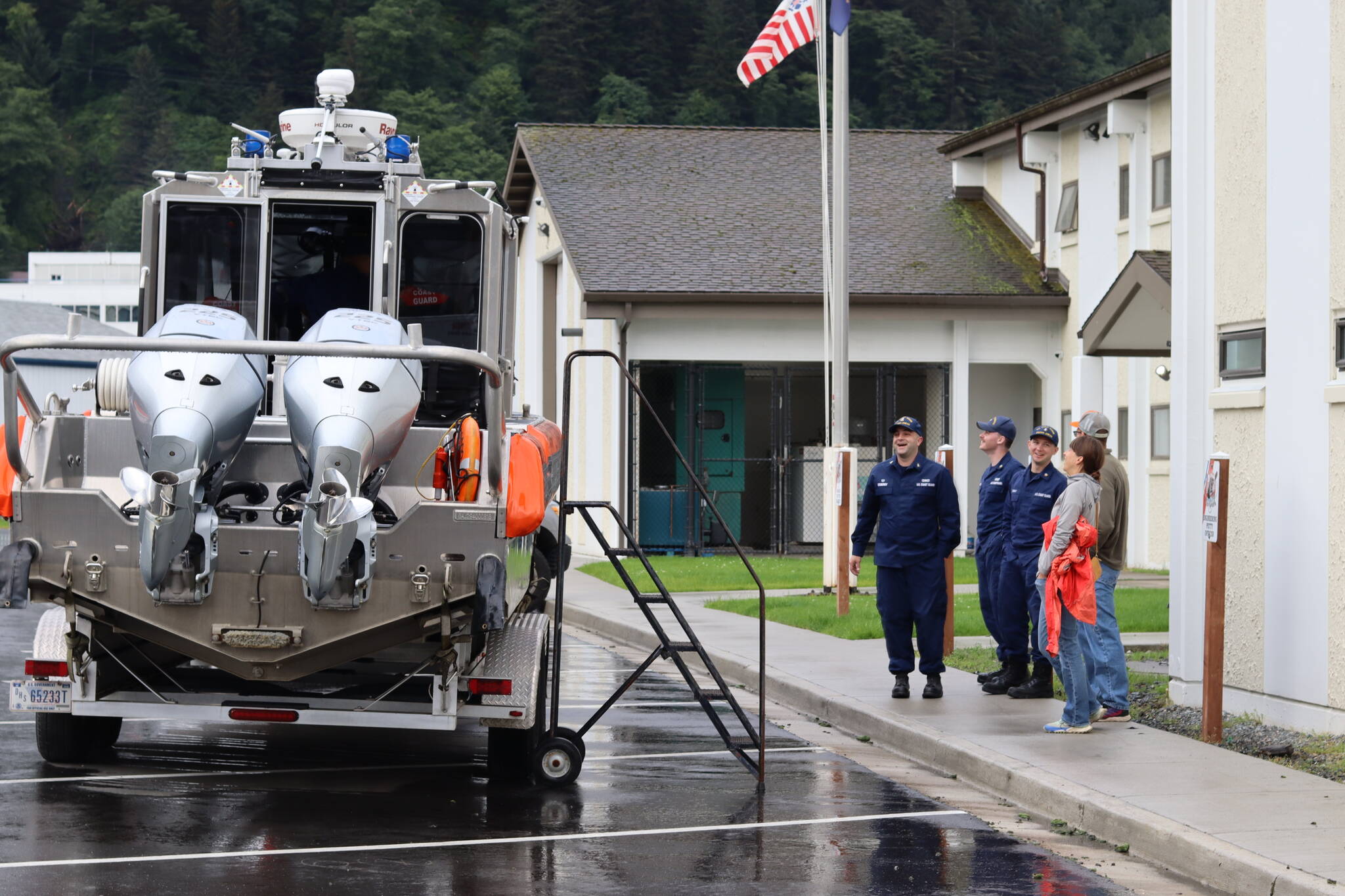 U.S. Coast Guard Chief Petty Officer Nicholas Sedberry is joined by other service members and visitors aside a 29-foot Coast Guard response boat during National Night Out events in Juneau on Tuesday. (Meredith Jordan / Juneau Empire)