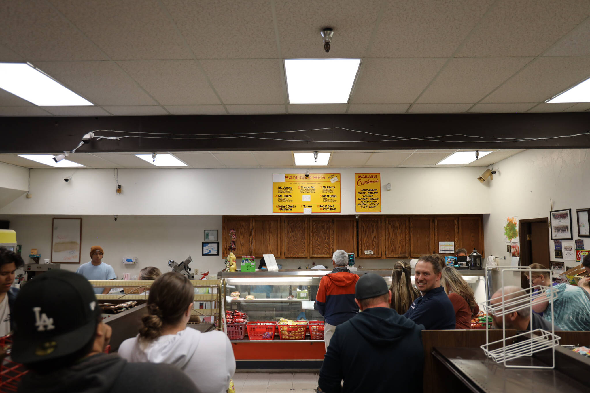 A crowd of customers surround the deli counter at J&J Deli and Asian Mart on Monday afternoon amid a lunch rush on the business’s last day open after more than four decades. (Clarise Larson / Juneau Empire)