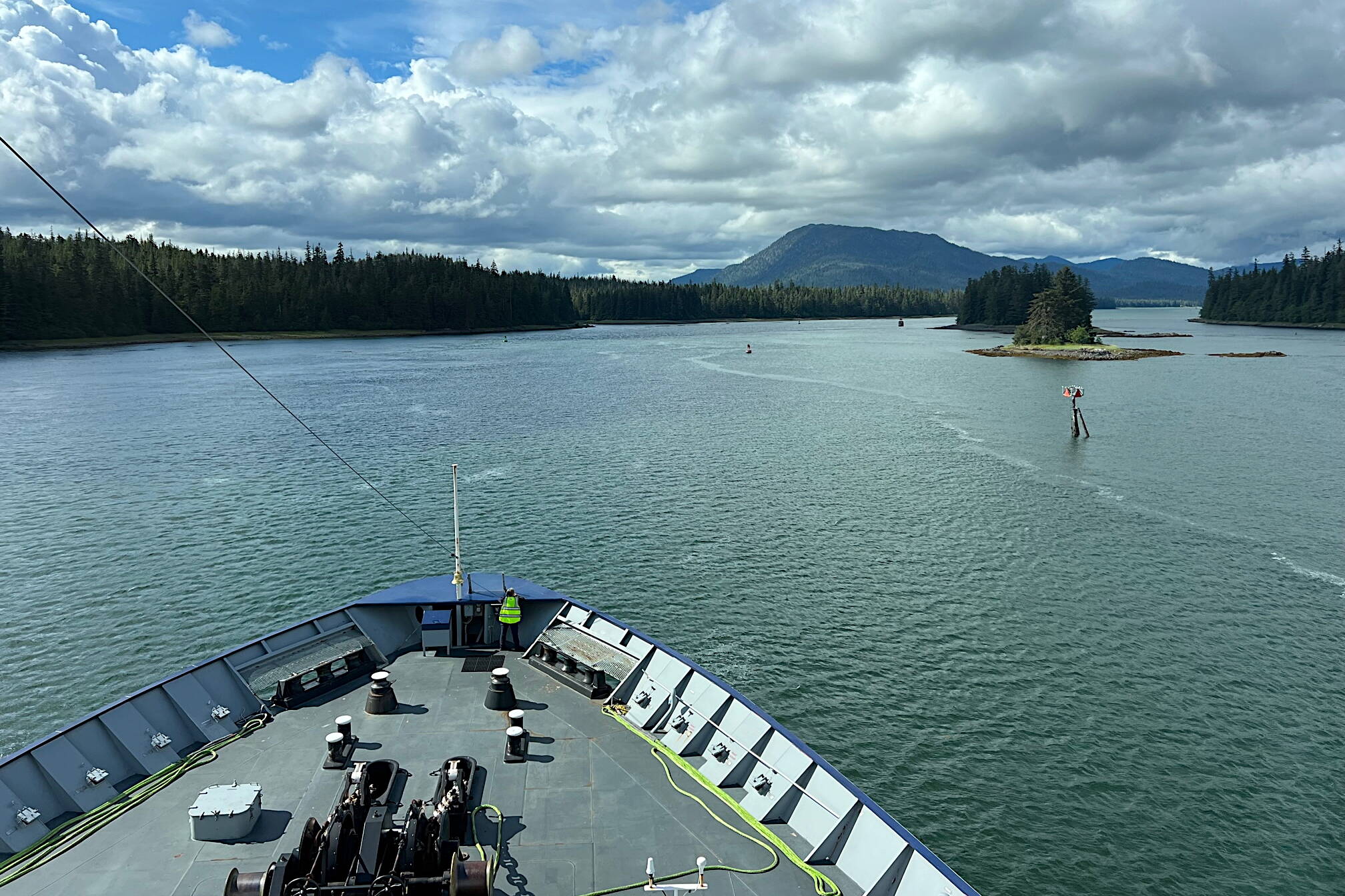 Ordinary Seaman Ann Griswold stands lookout on the foredeck of Columbia as it makes its way through the Wrangell Narrows. (Meredith Jordan / Juneau Empire)