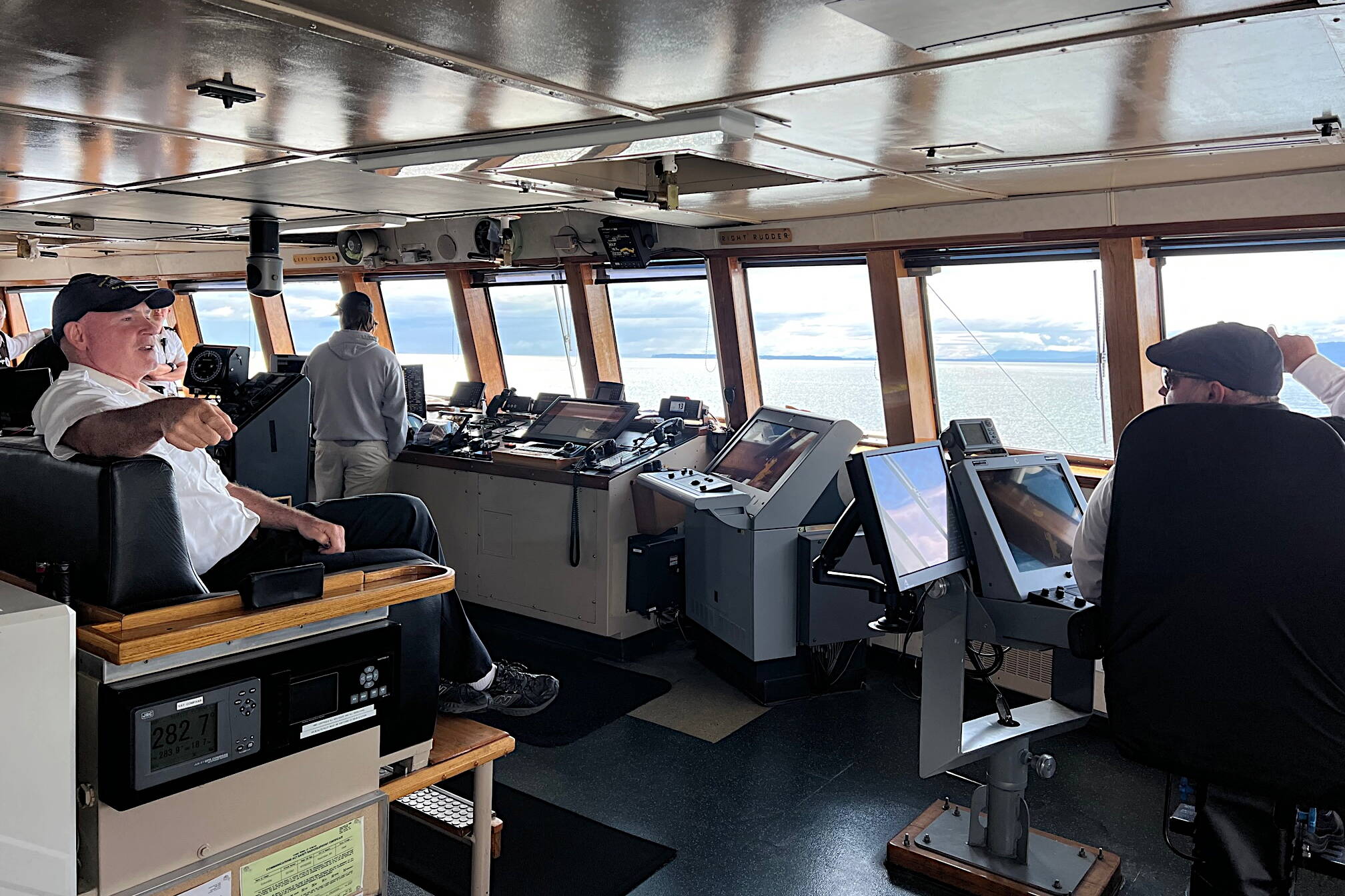 Capt. Dave Turner and Chief Mate Lucas Bevegni on the bridge of Columbia state ferry as Bevegni takes note of a whale spout more than a mile in the distance. (Meredith Jordan / Juneau Empire)